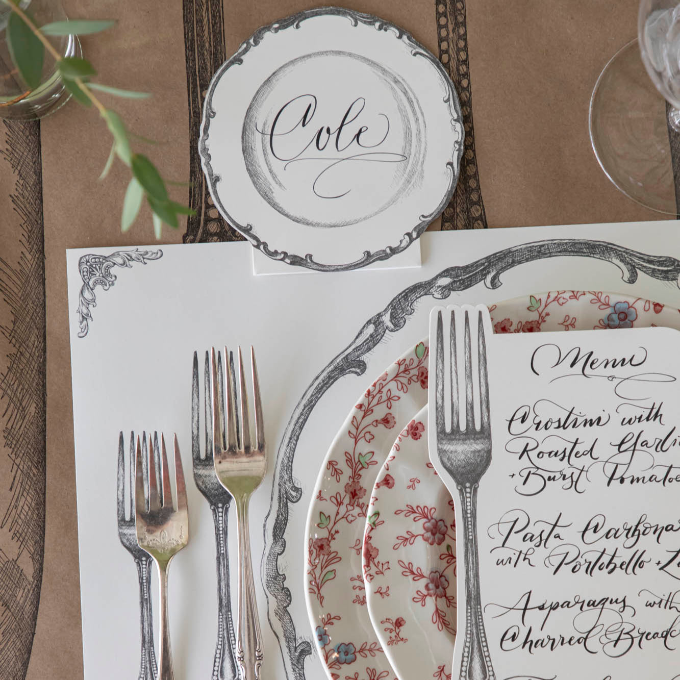 Vintage Plate Place Card with "Cole" written on it, laying flat behind a table setting for one.