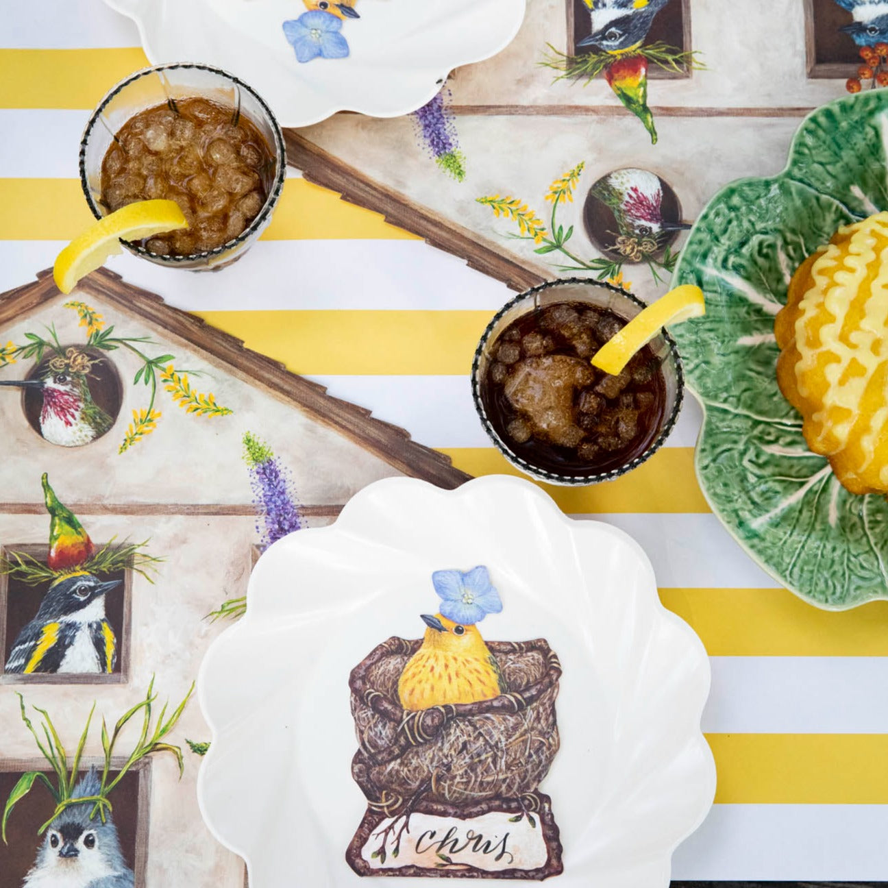 Top-down view of an elegant avian tablescape featuring Welcome Warbler Place Cards laying flat on each plate.