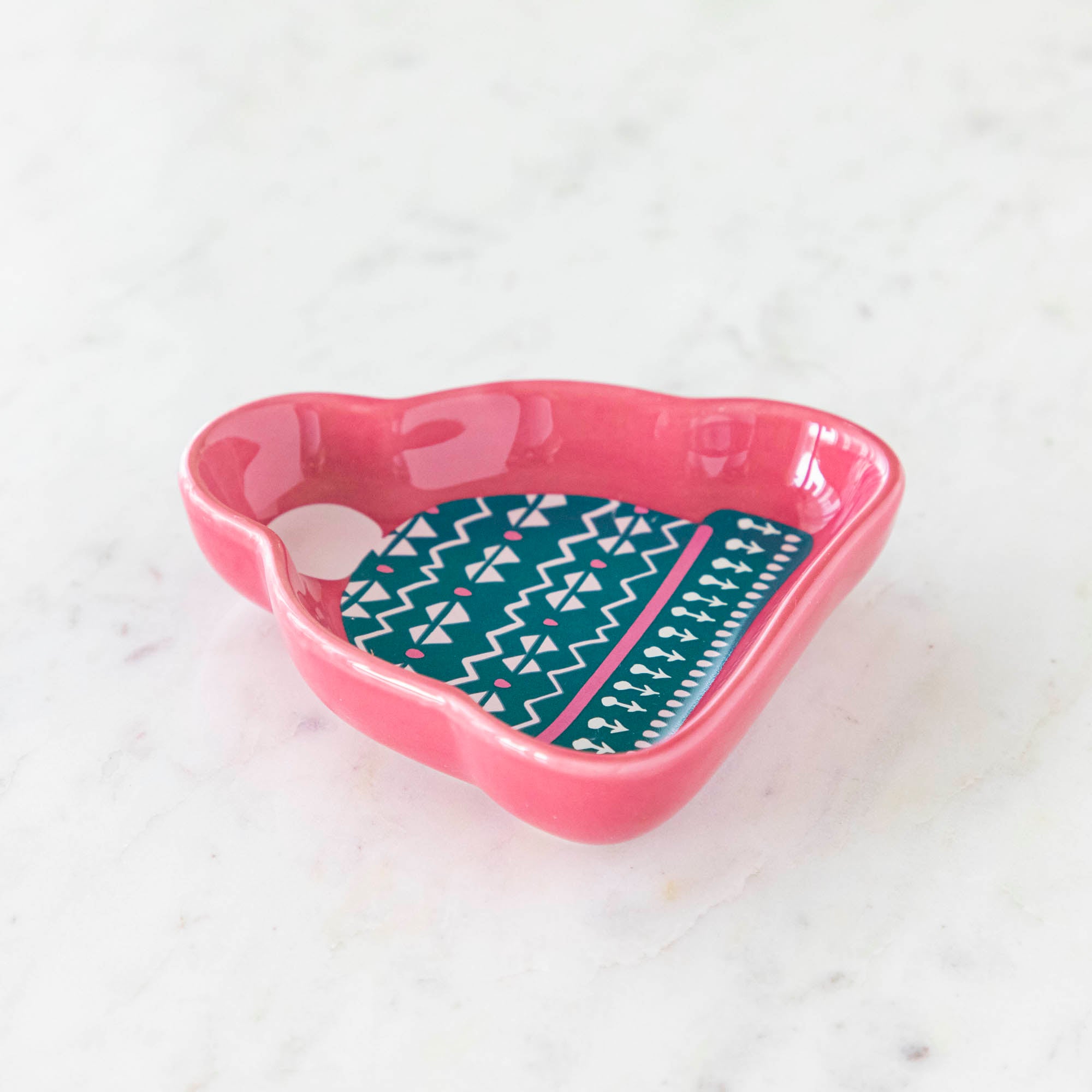 A stoneware pinch bowl with a beanie shape featuring a Christmas-themed pattern.