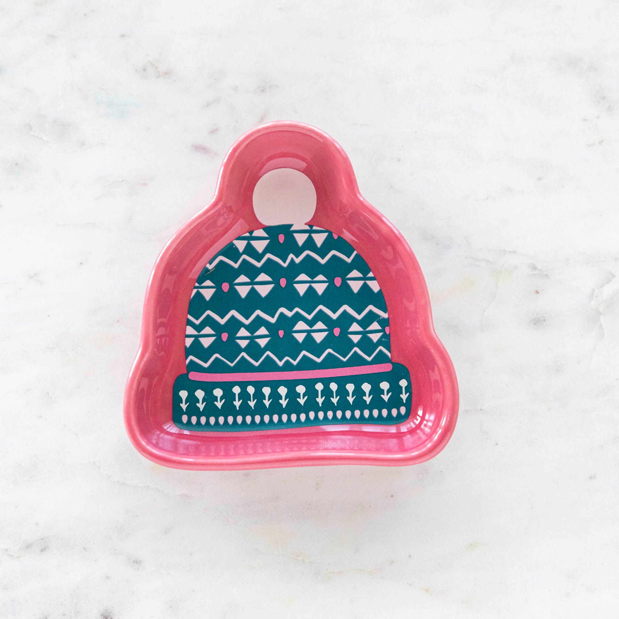 A stoneware pinch bowl with a beanie shape featuring a Christmas-themed pattern.