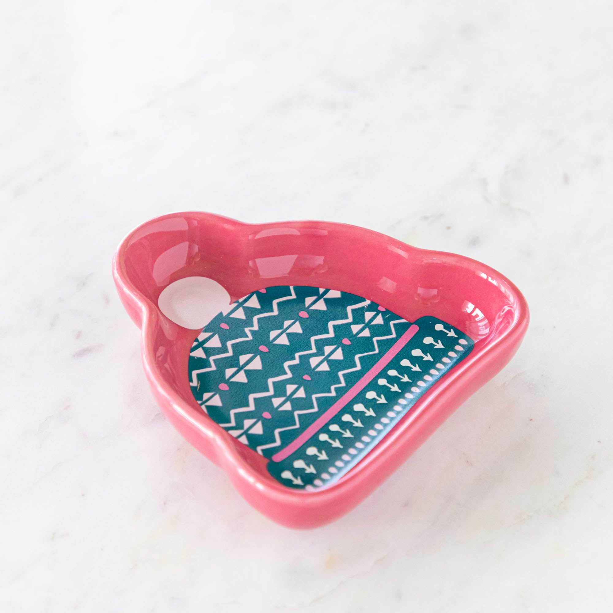 A stoneware pinch bowl with a beanie shape featuring a Christmas-themed pattern.