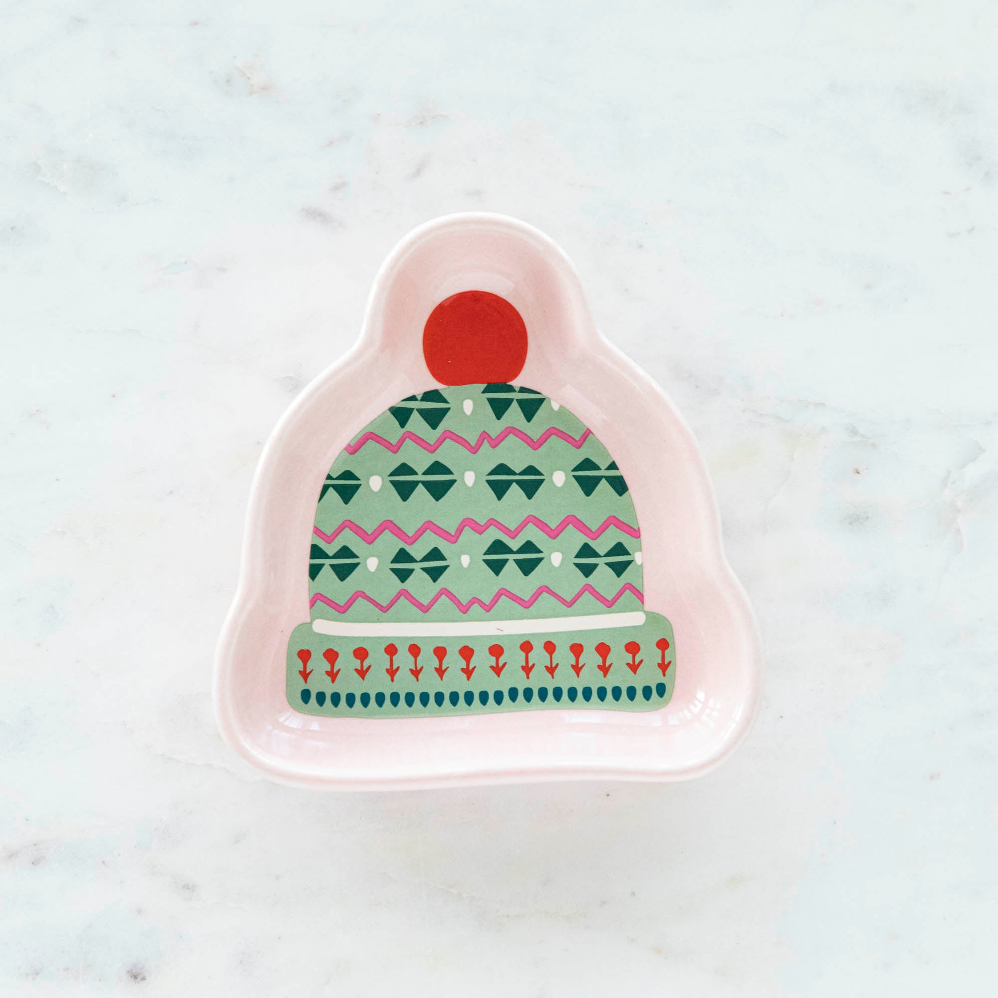 A stoneware pinch bowl with a beanie shape featuring a Christmas-themed pattern.