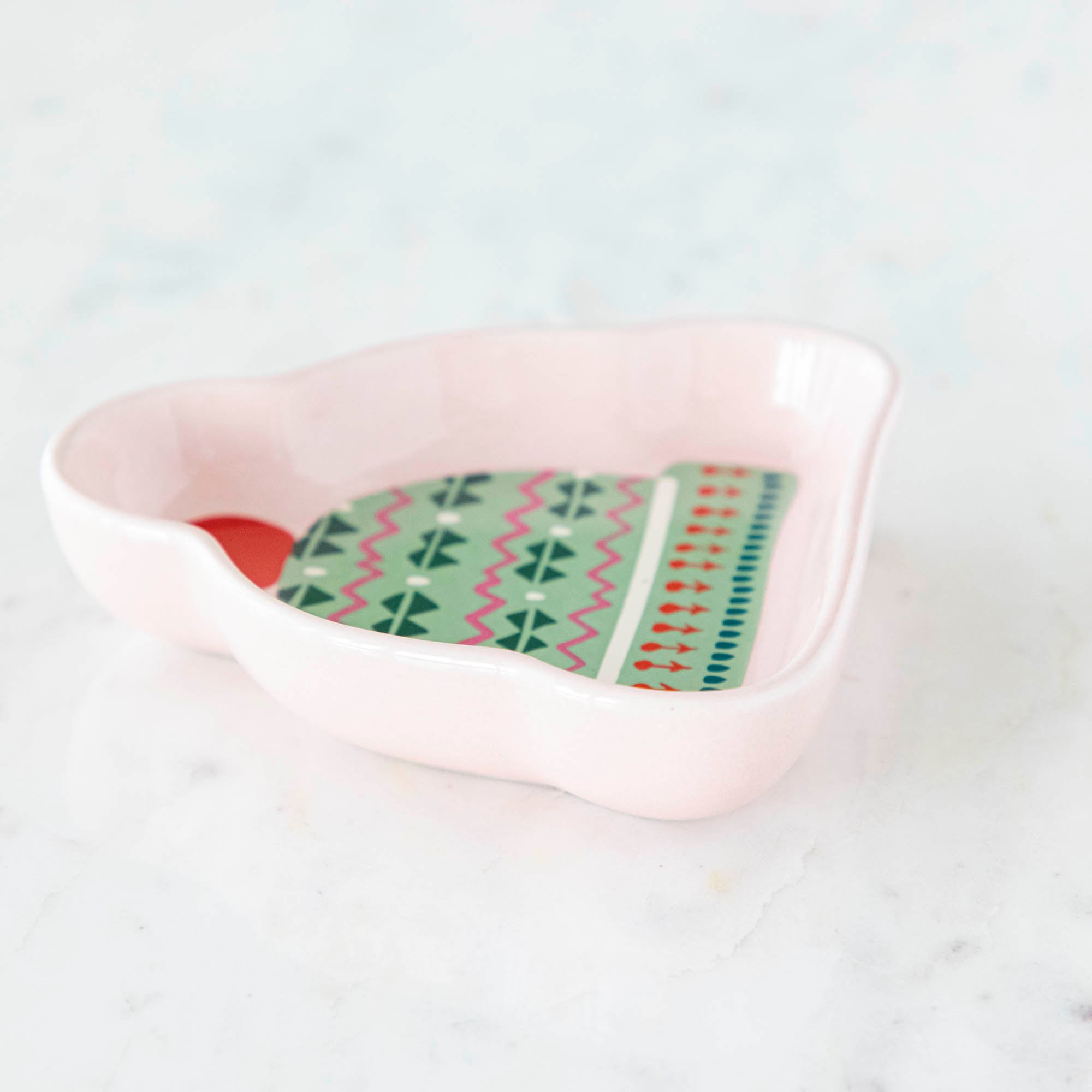 A stoneware pinch bowl with a beanie shape featuring a Christmas-themed pattern.