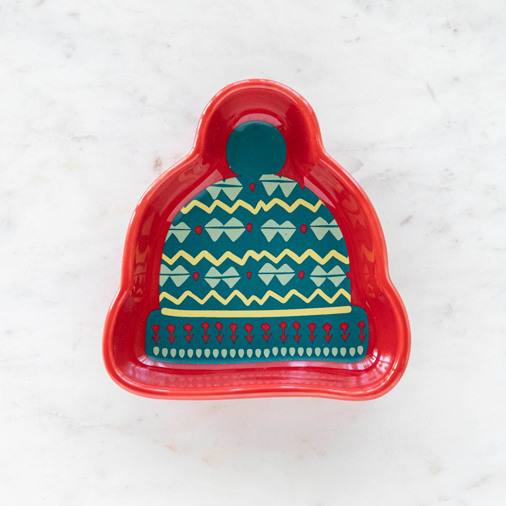 A stoneware pinch bowl with a beanie shape featuring a Christmas-themed pattern.