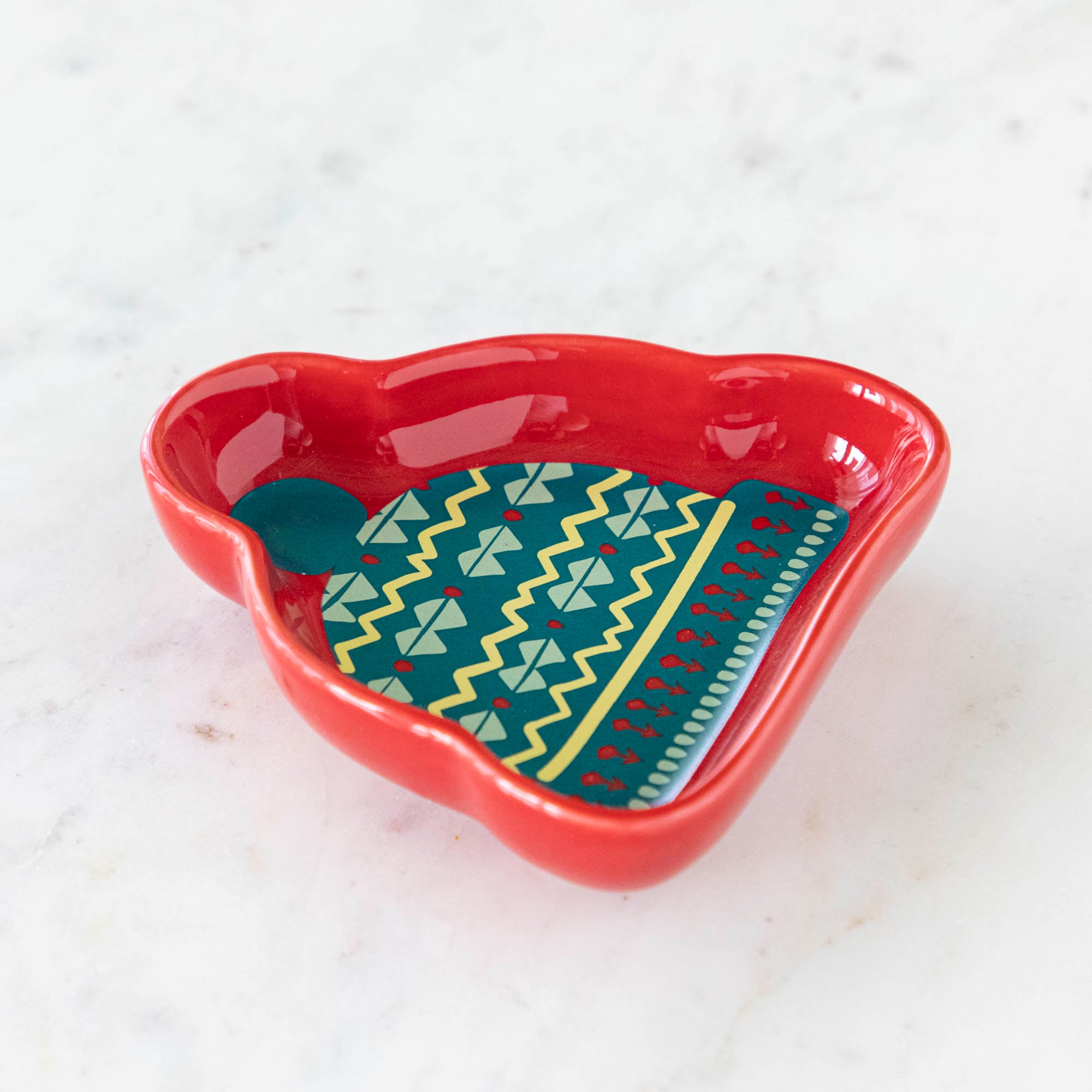 A stoneware pinch bowl with a beanie shape featuring a Christmas-themed pattern.