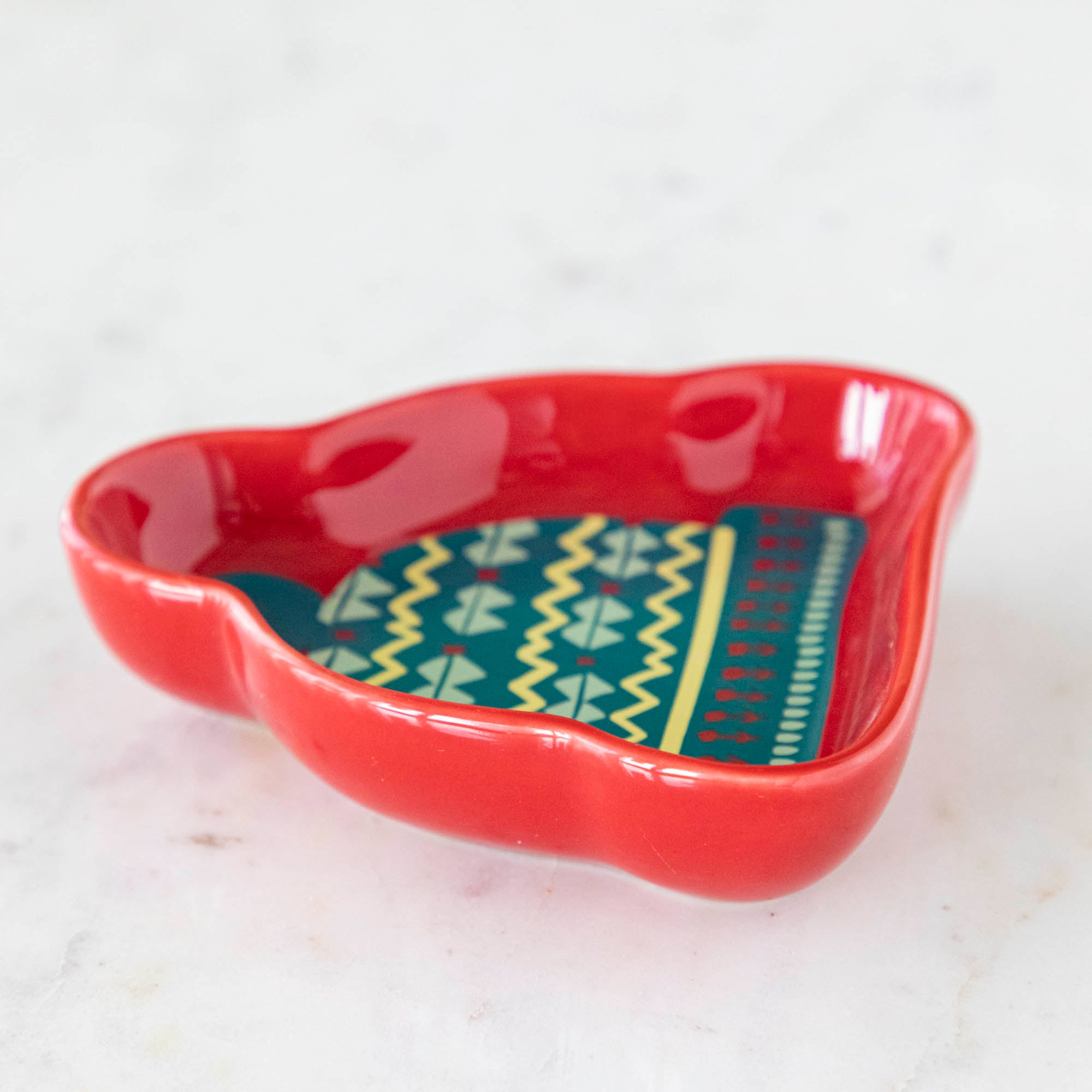 A stoneware pinch bowl with a beanie shape featuring a Christmas-themed pattern.