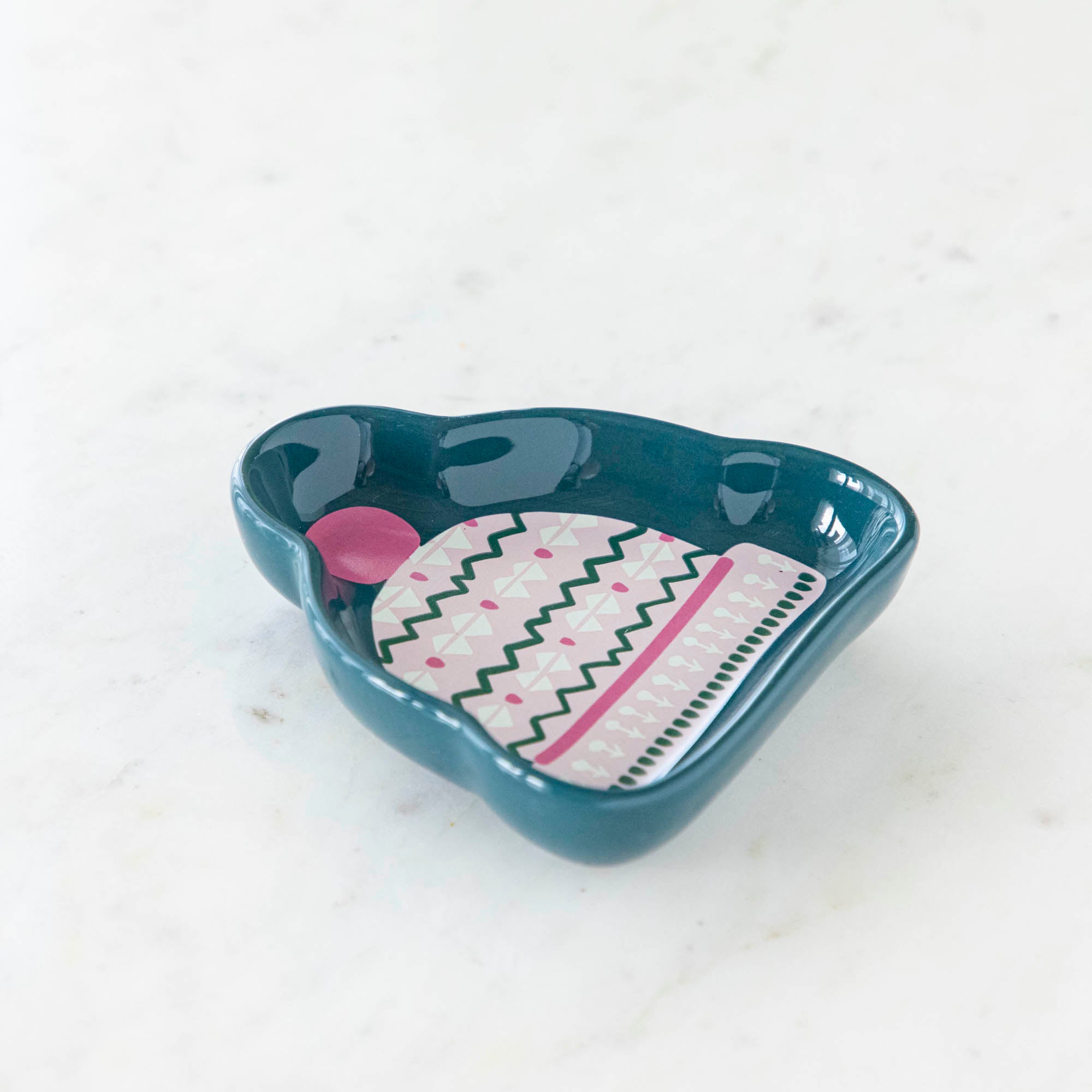 A stoneware pinch bowl with a beanie shape featuring a Christmas-themed pattern.