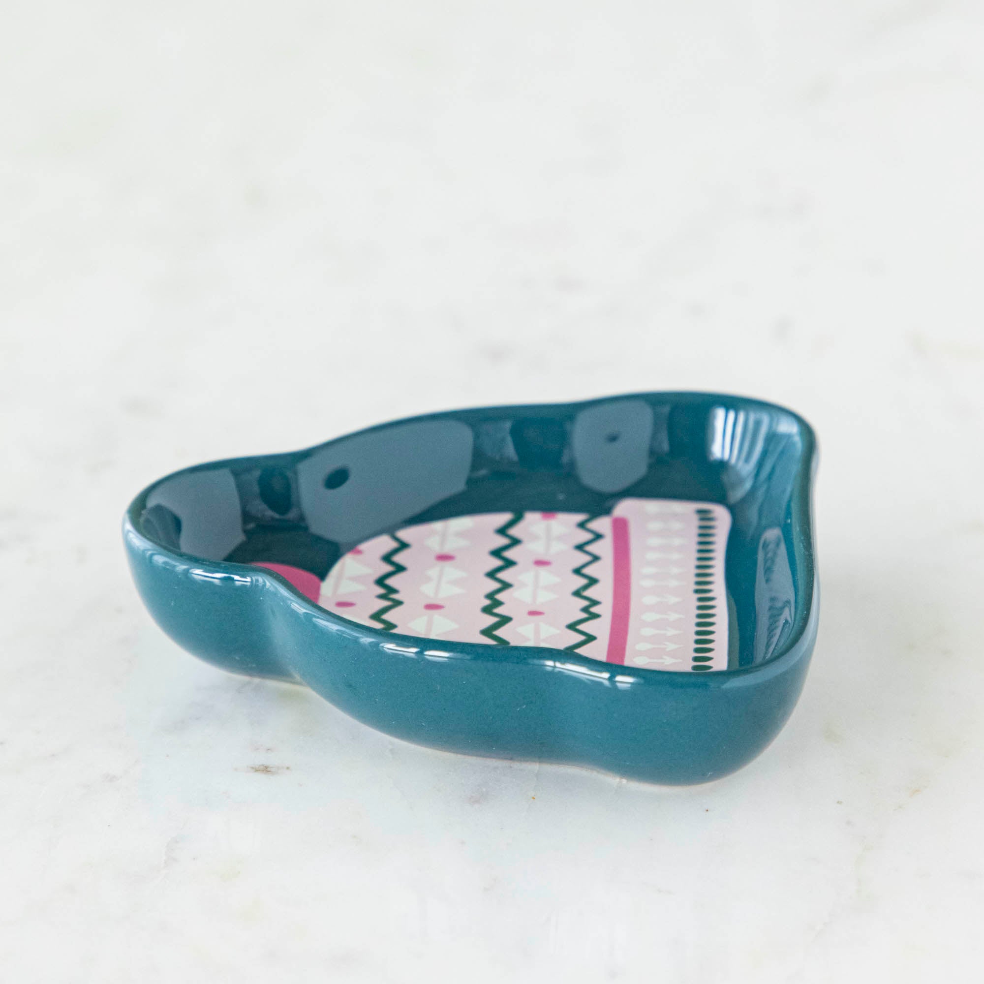 A stoneware pinch bowl with a beanie shape featuring a Christmas-themed pattern.
