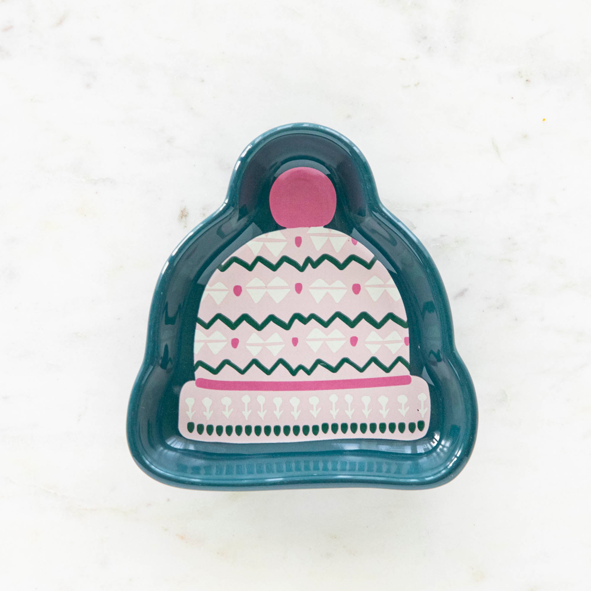 A stoneware pinch bowl with a beanie shape featuring a Christmas-themed pattern.