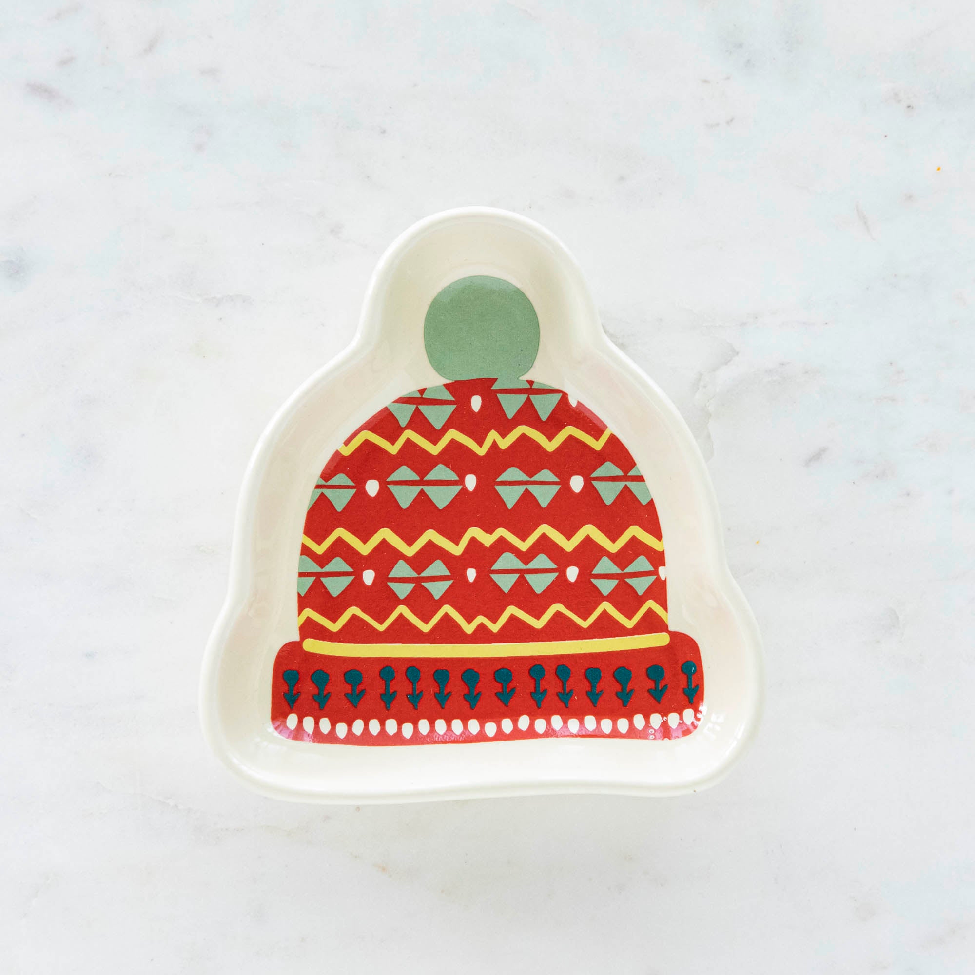 A stoneware pinch bowl with a beanie shape featuring a Christmas-themed pattern.