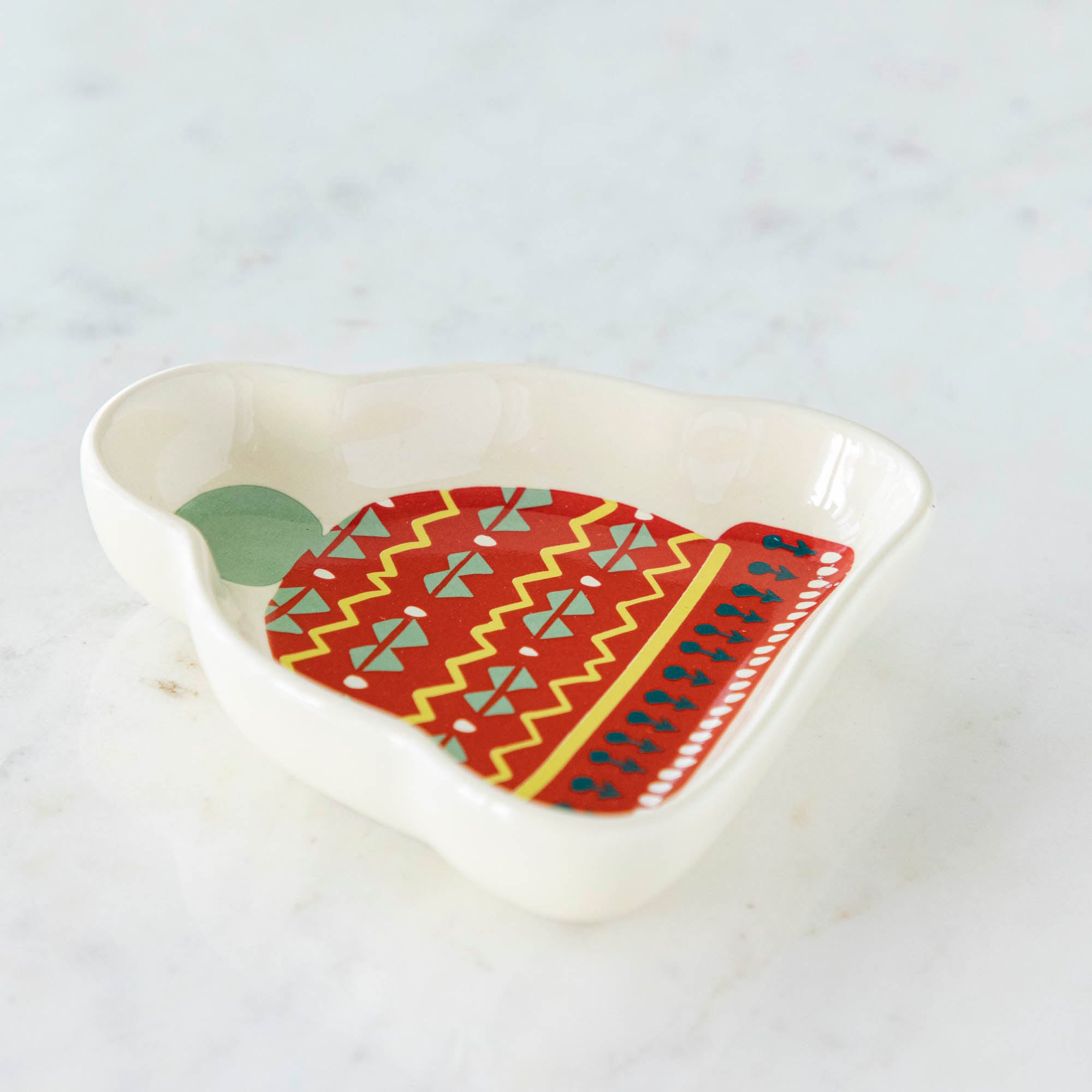 A stoneware pinch bowl with a beanie shape featuring a Christmas-themed pattern.