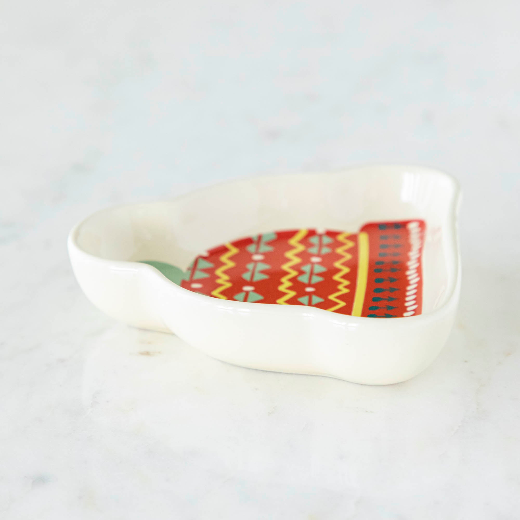 A stoneware pinch bowl with a beanie shape featuring a Christmas-themed pattern.