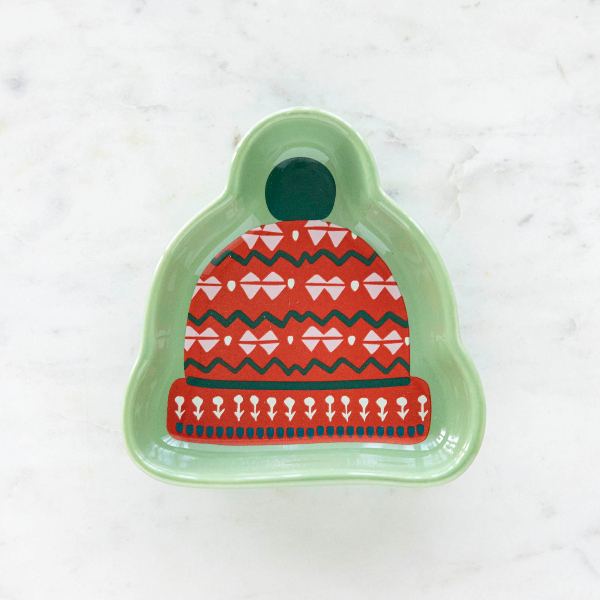 A stoneware pinch bowl with a beanie shape featuring a Christmas-themed pattern.