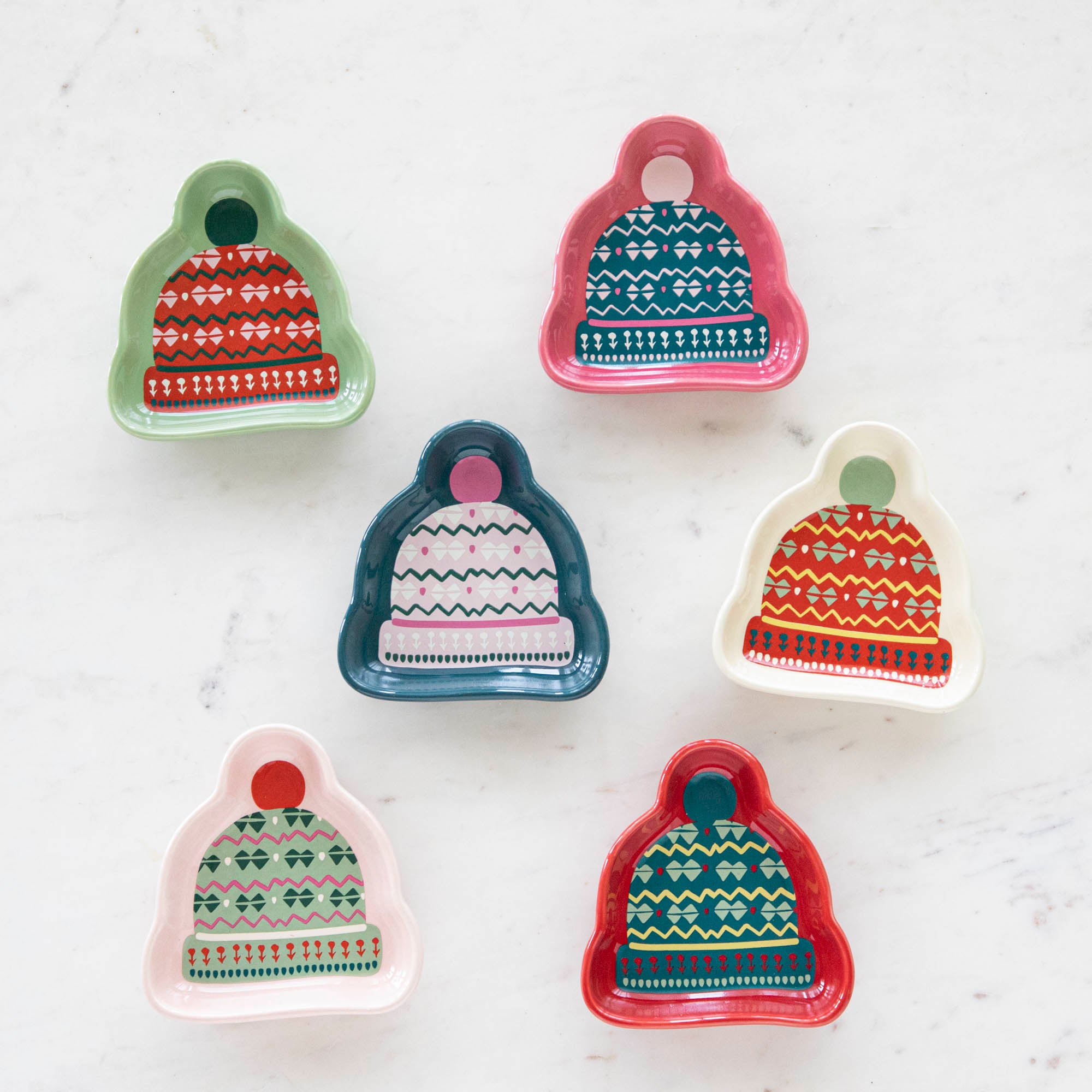 A set of stoneware pinch bowls with a beanie shape, featuring various Christmas-themed patterns in red, green, and white colors.