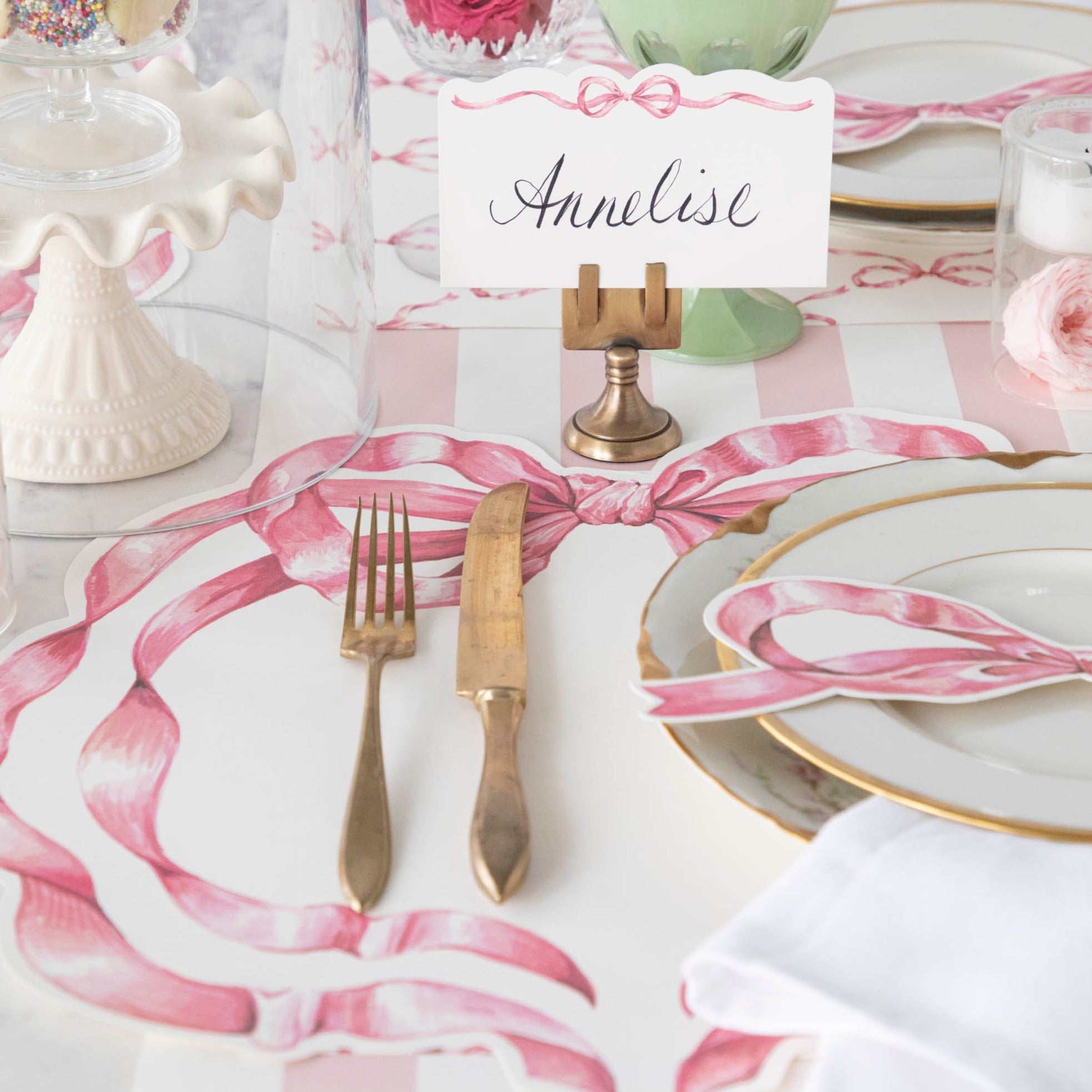 An elegant tablescape featuring a Brass Place Card Holder holding a card reading "Annelise".