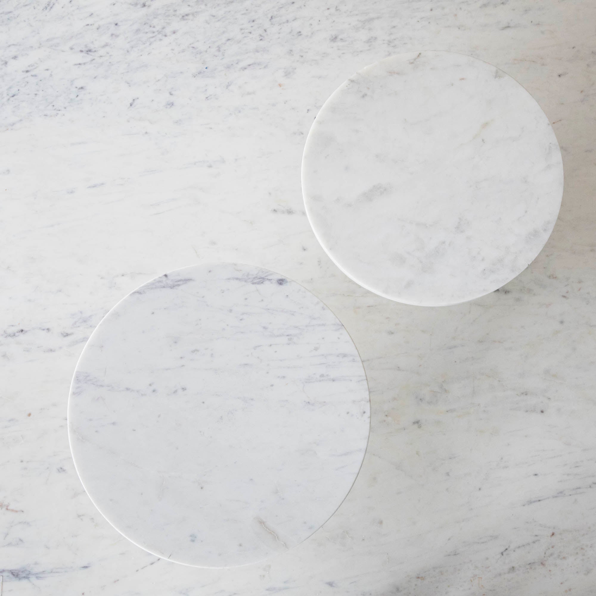 A bouquet of white hydrangeas in a white vase on a Bidk Home Marble Cake Plate with Antique Brass Base with decorative tables and a textured background.