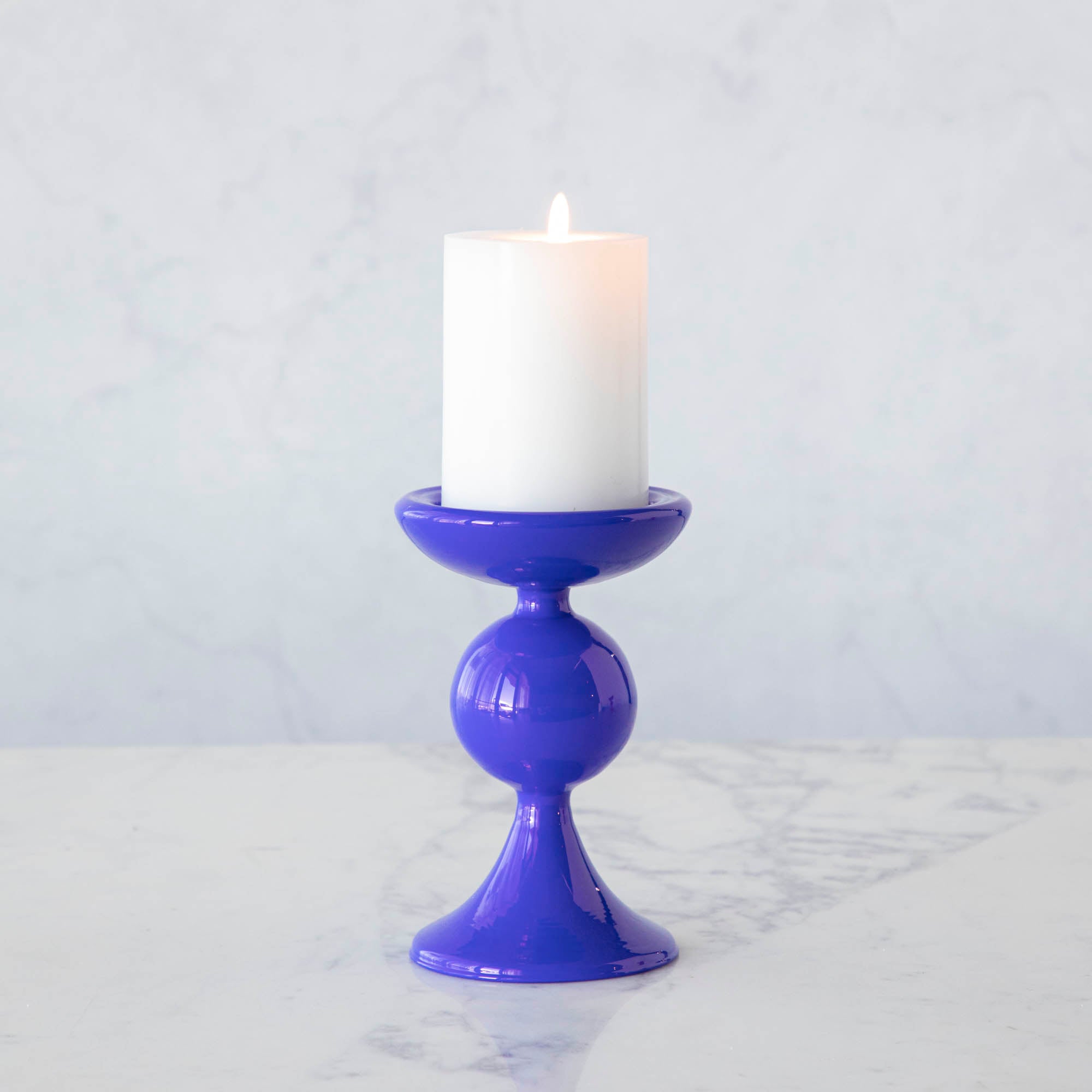 A group of Glitterville Sweet Bubble Pillar Candle Holders in vibrant colors with a candle in the middle.