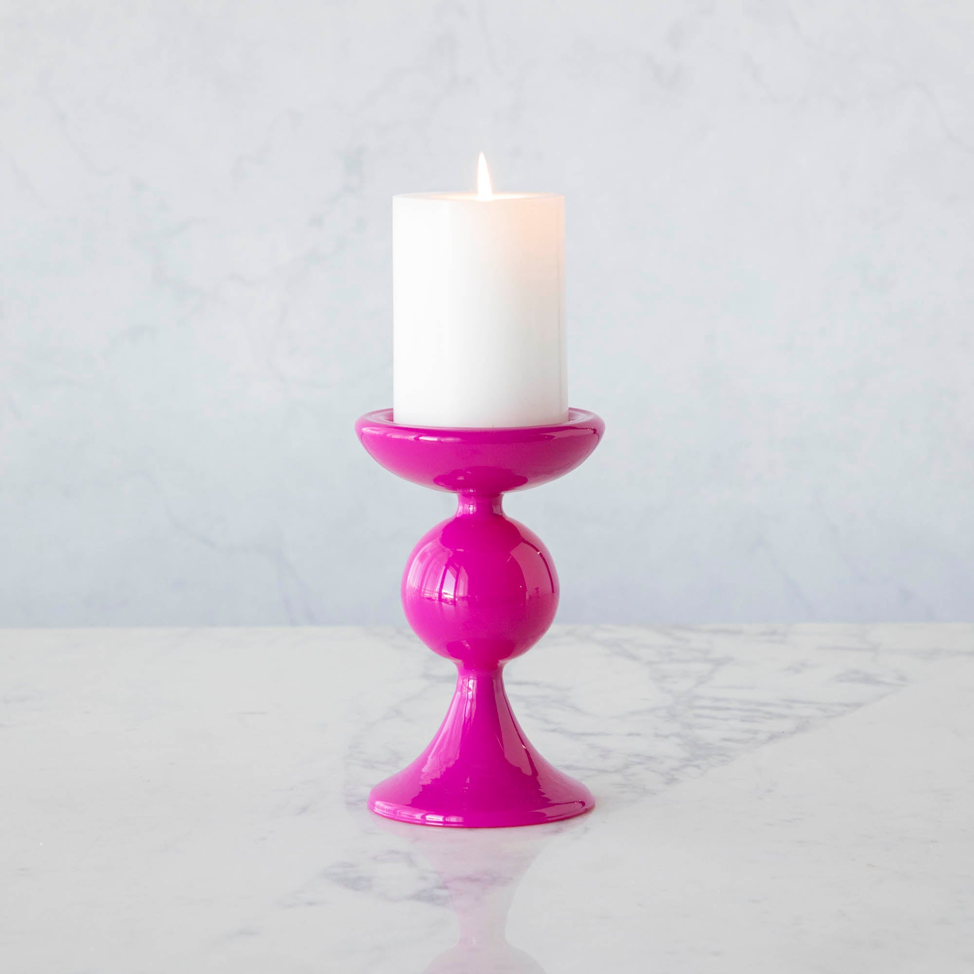A group of Glitterville Sweet Bubble Pillar Candle Holders in vibrant colors with a candle in the middle.