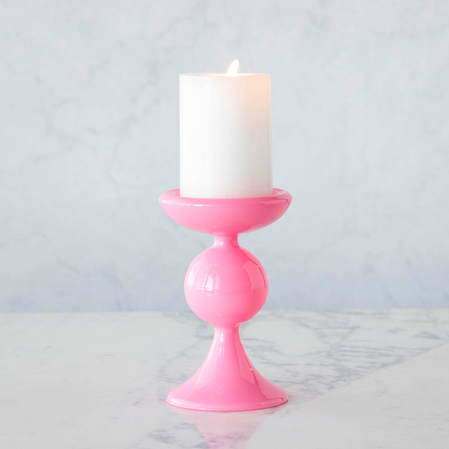 A group of Glitterville Sweet Bubble Pillar Candle Holders in vibrant colors with a candle in the middle.