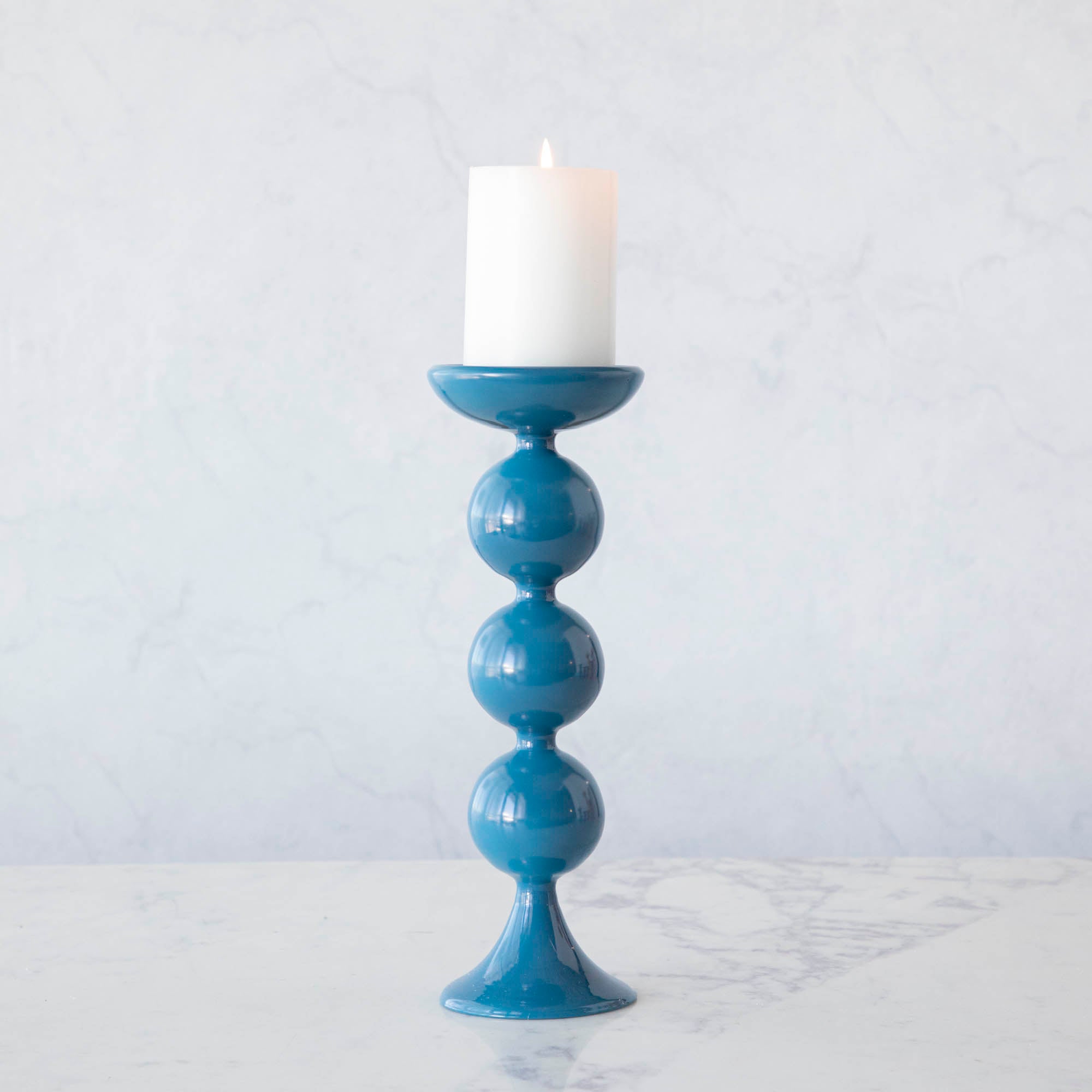 A group of Glitterville Sweet Bubble Pillar Candle Holders in vibrant colors with a candle in the middle.