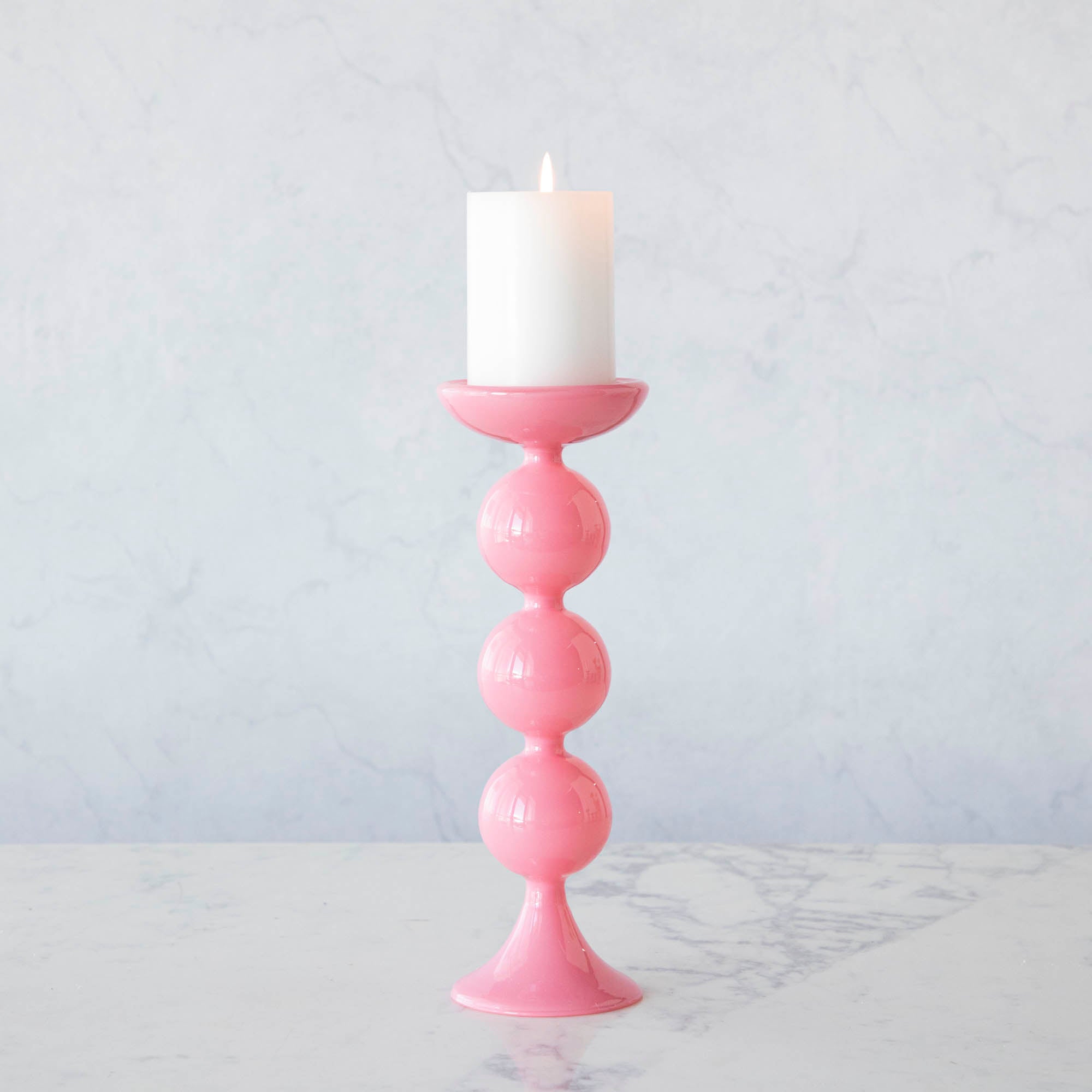 A group of Glitterville Sweet Bubble Pillar Candle Holders in vibrant colors with a candle in the middle.