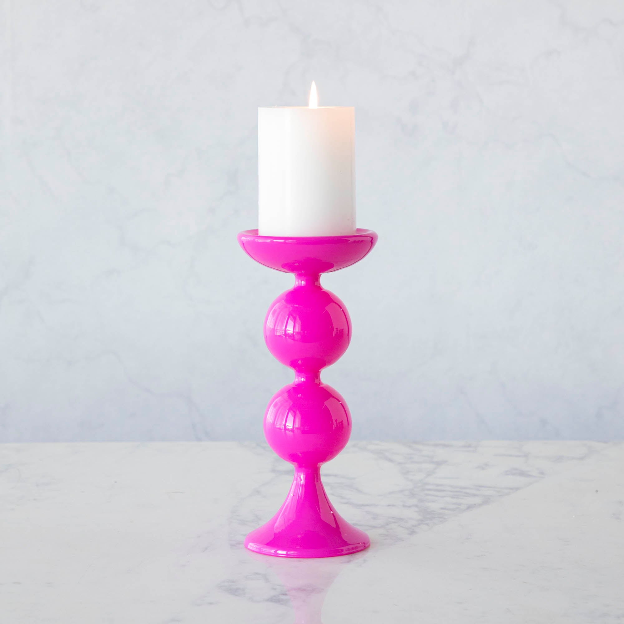 A group of Glitterville Sweet Bubble Pillar Candle Holders in vibrant colors with a candle in the middle.