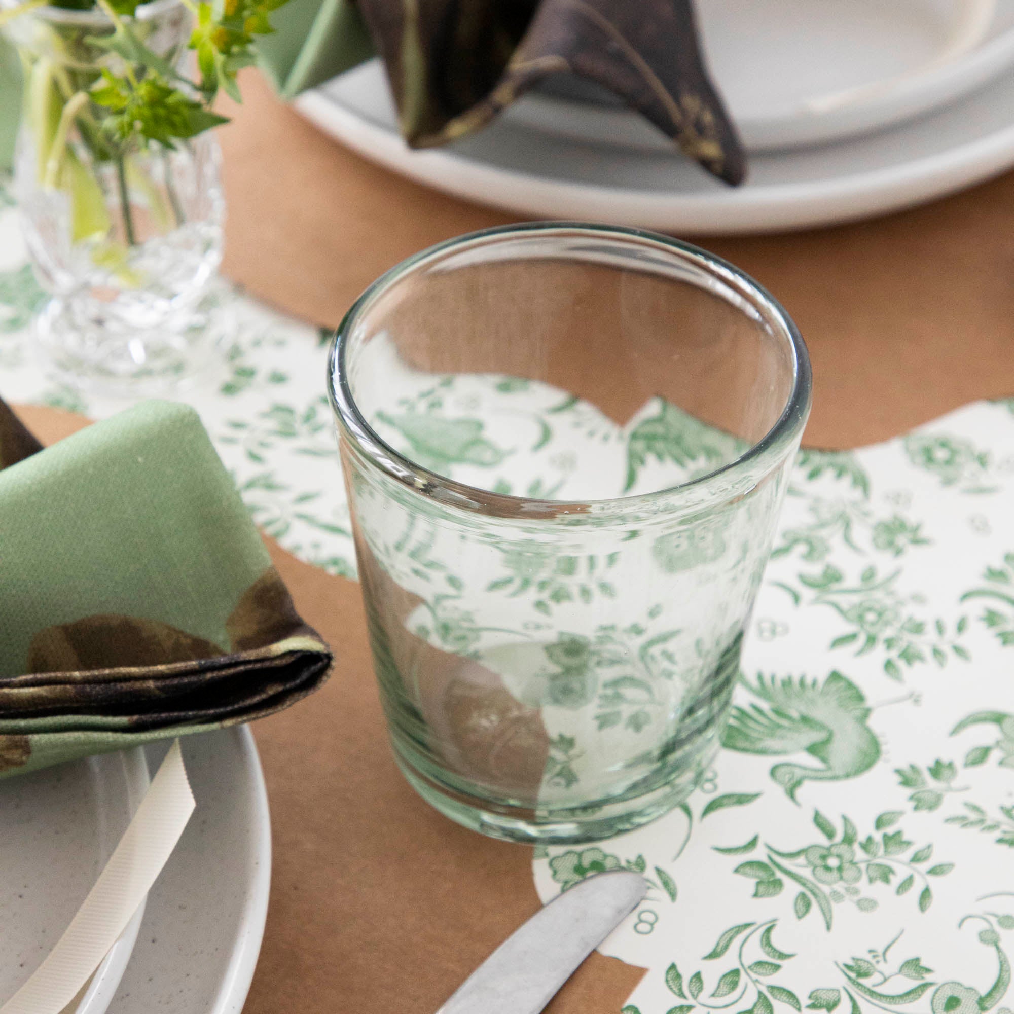 Three empty Margarida Recycled Glasses vessels of varying heights and shapes, made by Casafina Living, rest on a white surface.