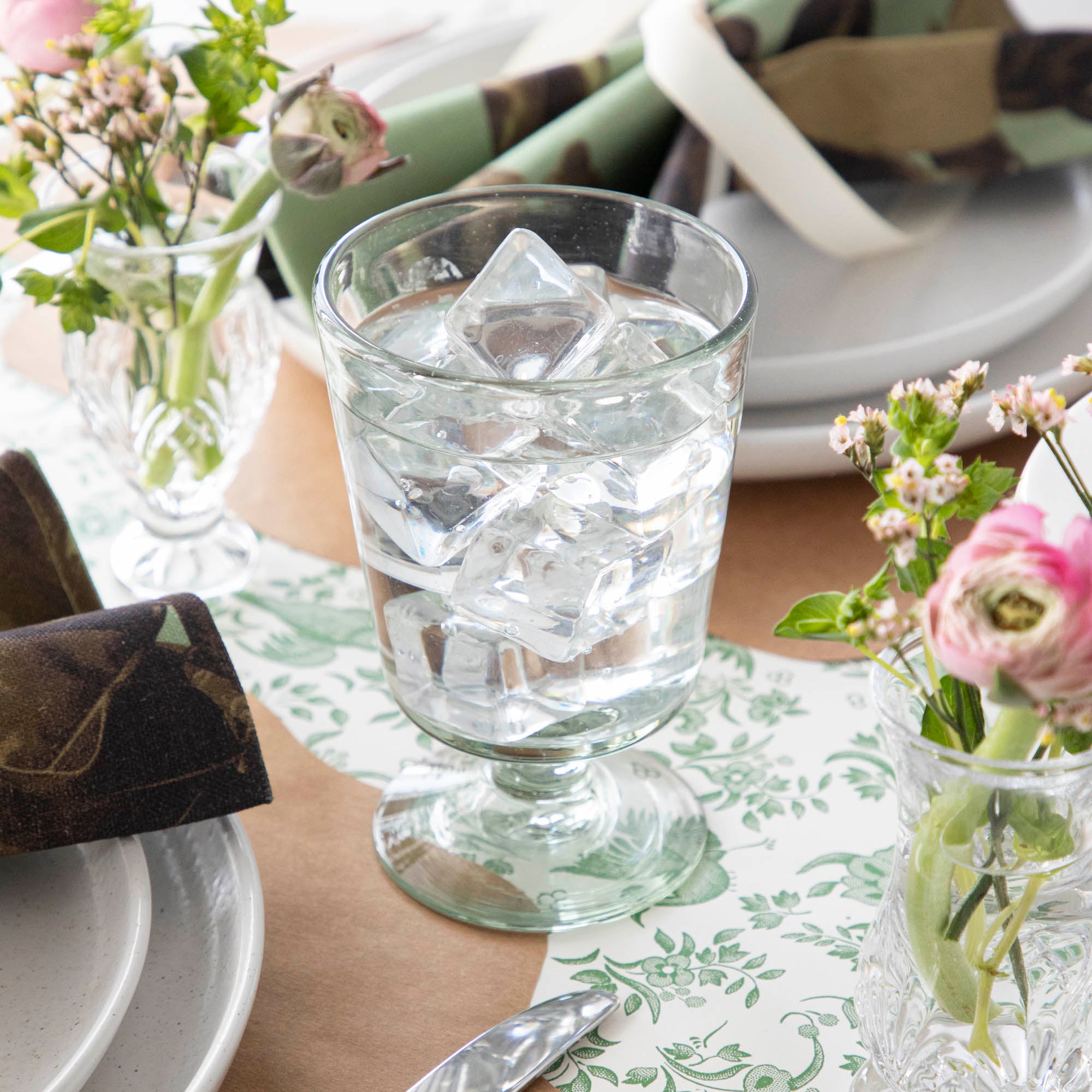 Three empty Margarida Recycled Glasses vessels of varying heights and shapes, made by Casafina Living, rest on a white surface.