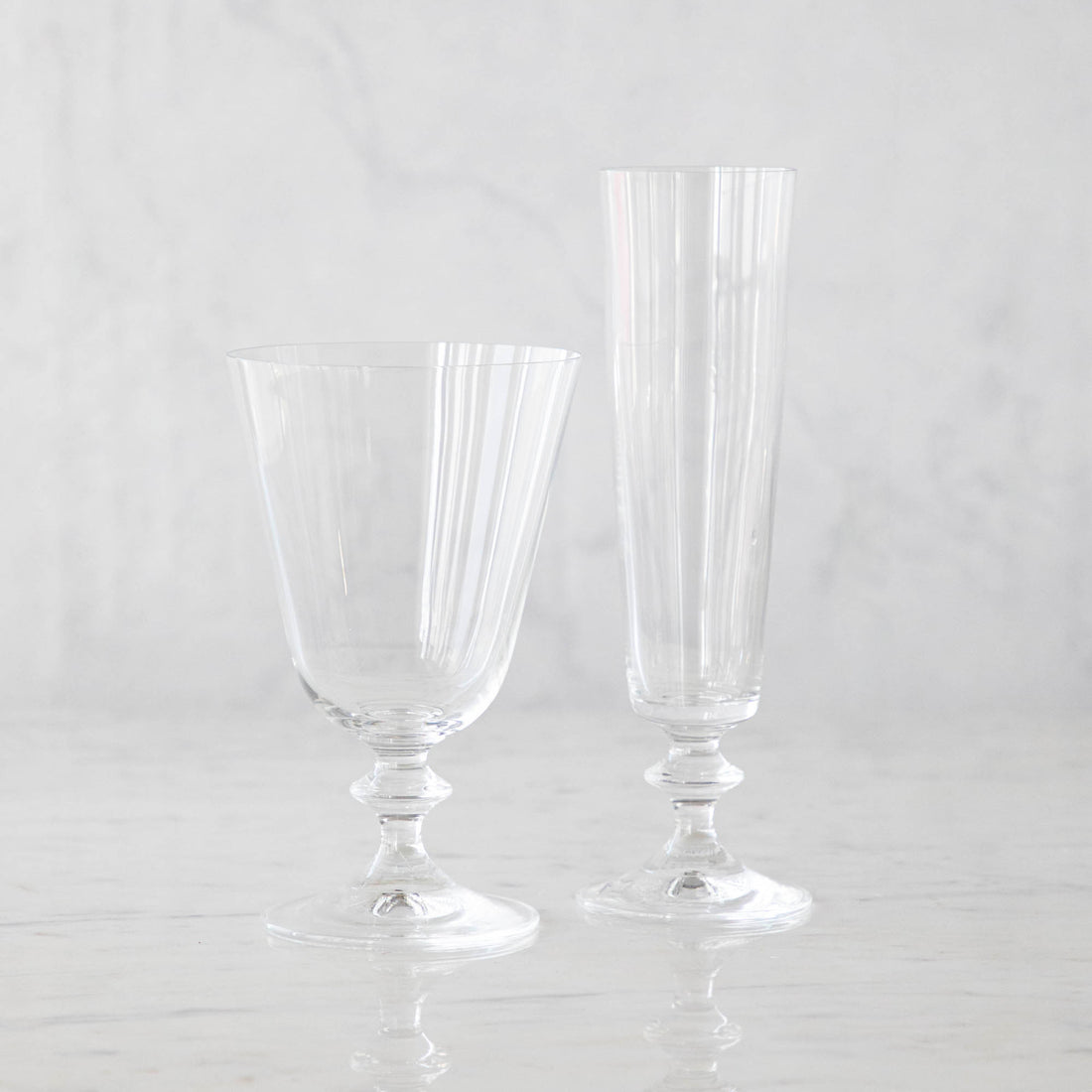 Two Riva Glassware pieces by Casafina Living on a marble surface.