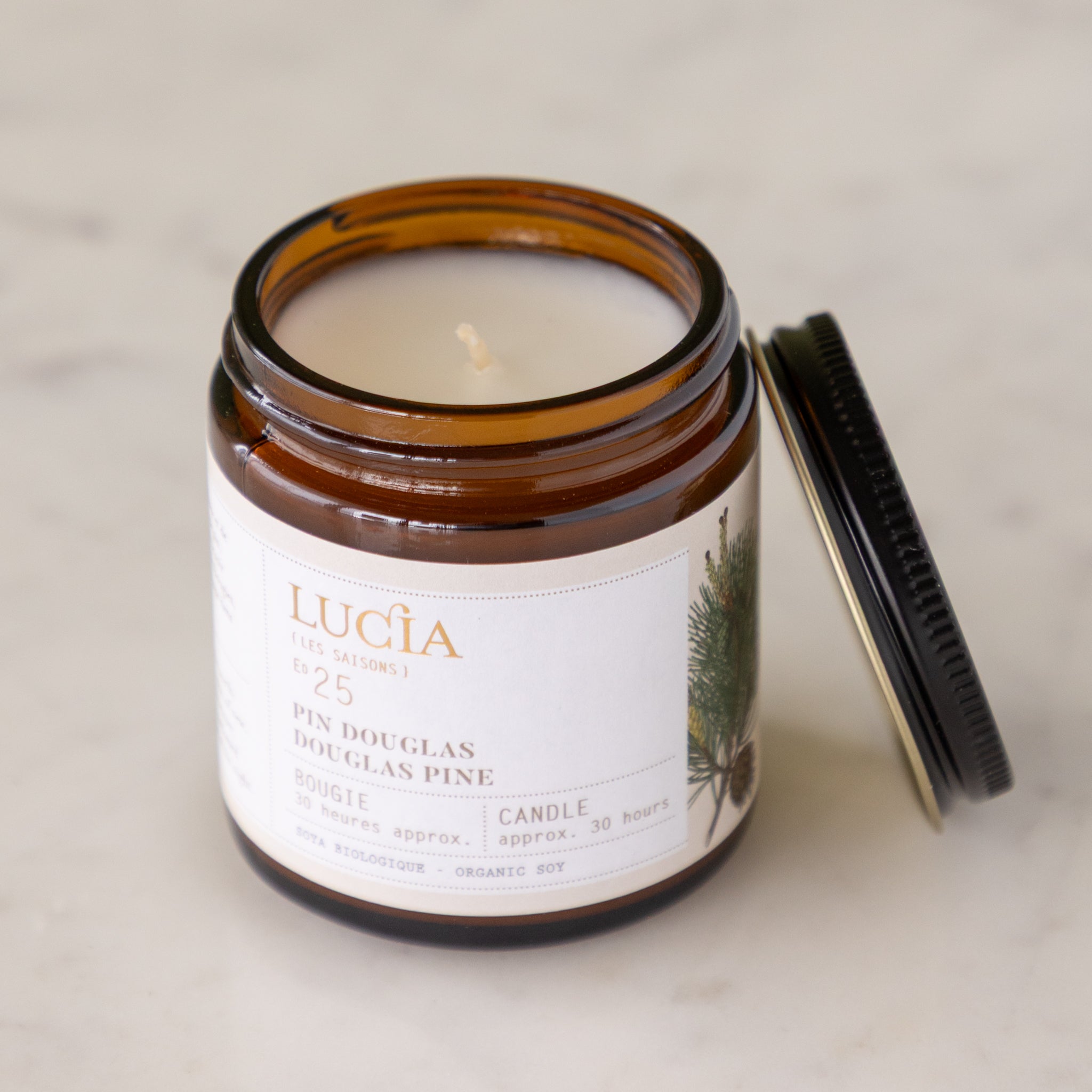 Lucia candle in a glass jar with a label on a neutral background