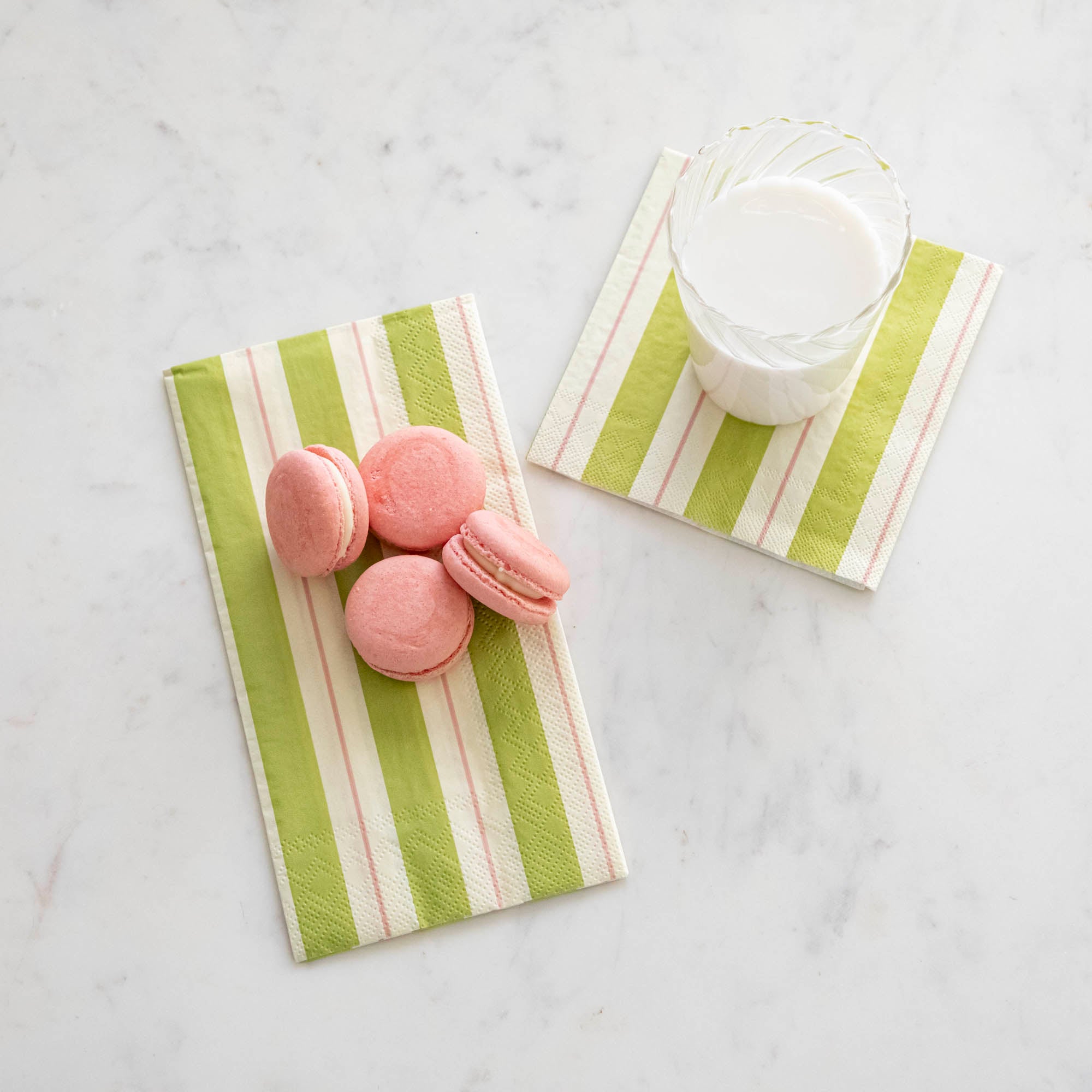Green & Pink Awning Stripe Napkins with a glass of milk and macaroons on top.