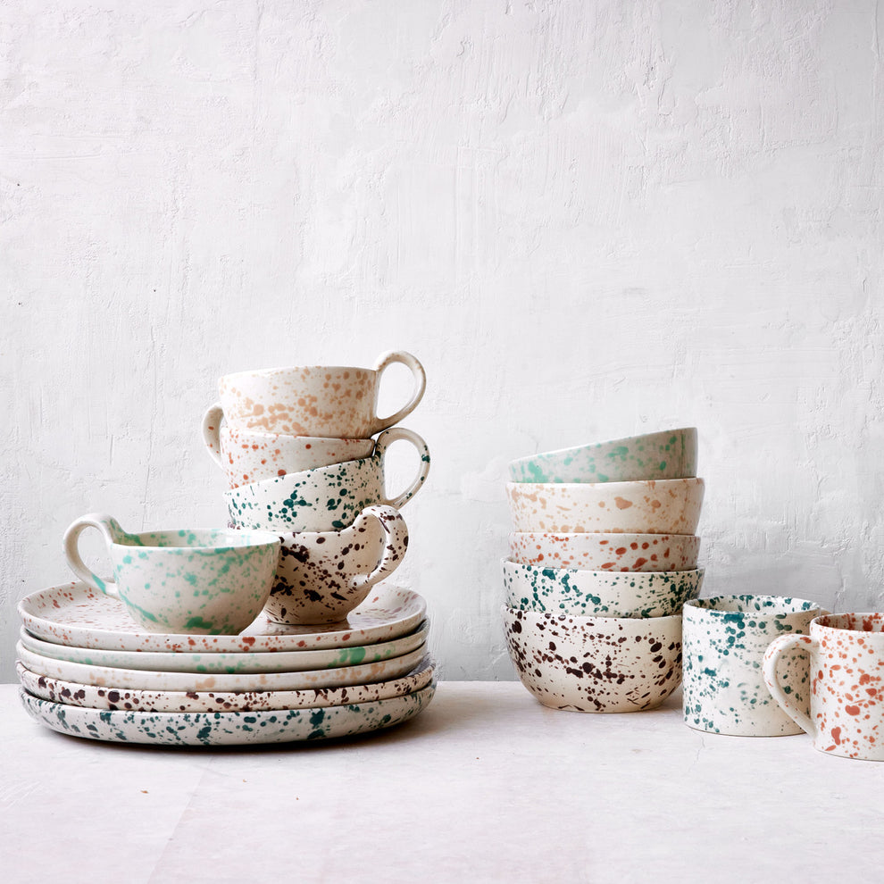 Set of ceramic dishes with speckled patterns on a light background