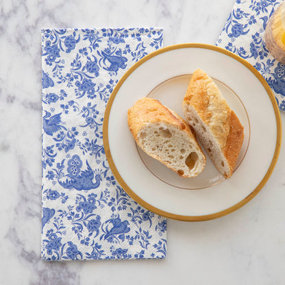 A plate of bread on top of a Blue Regal Peacock Guest Napkin by Hester &amp; Cook.