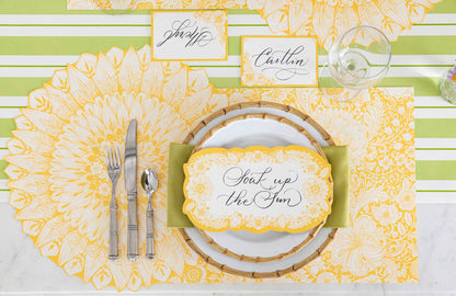 A Spring Blooms Table Card with &quot;Soak up the sun&quot; written on it in lovely script resting on the plate of a vibrant place setting.