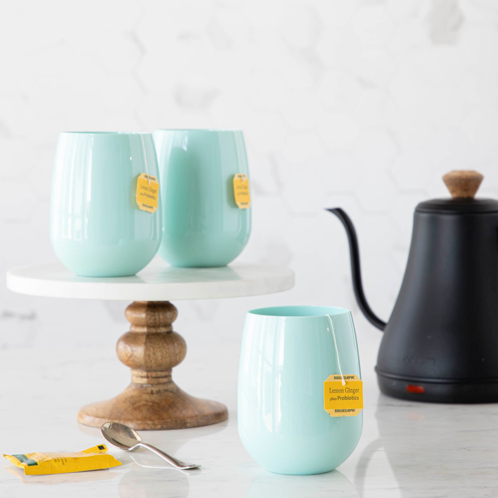 3 Seafoam SymGlasses with tea bags and tea kettle in the background.