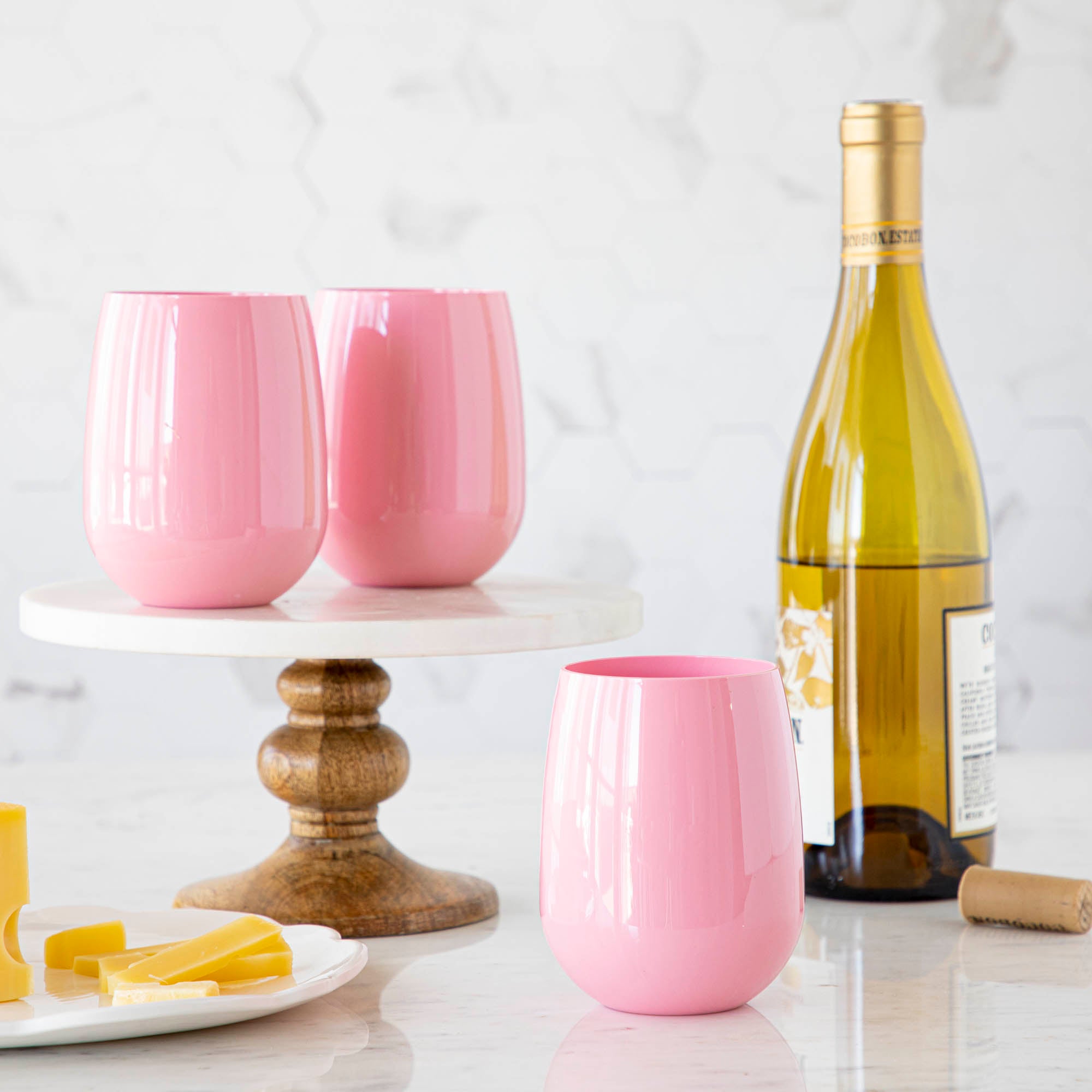 3 Pink SymGlasses with a bottle of wine in the background.