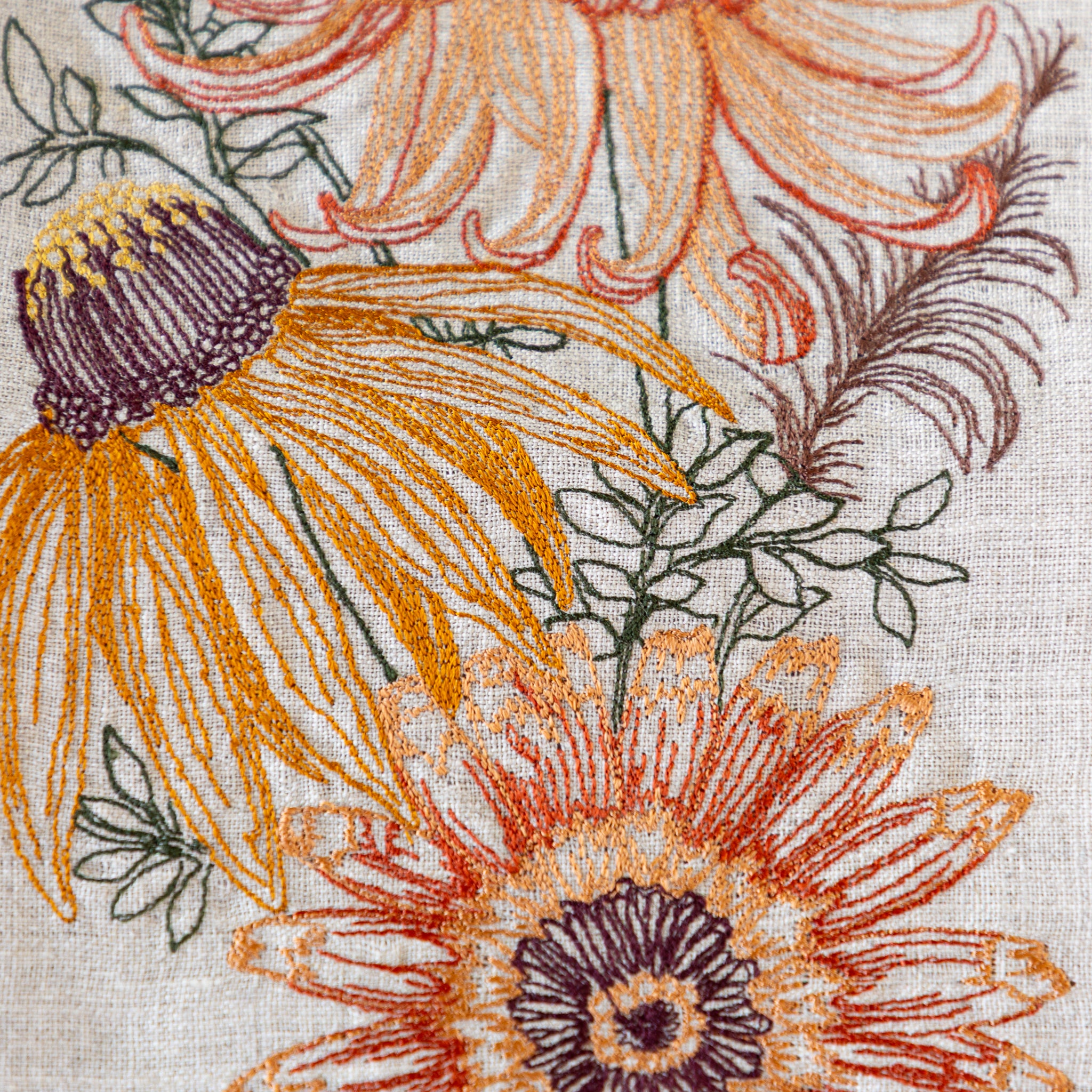 Close-up of a floral pattern with orange and purple flowers on a textured fabric background.