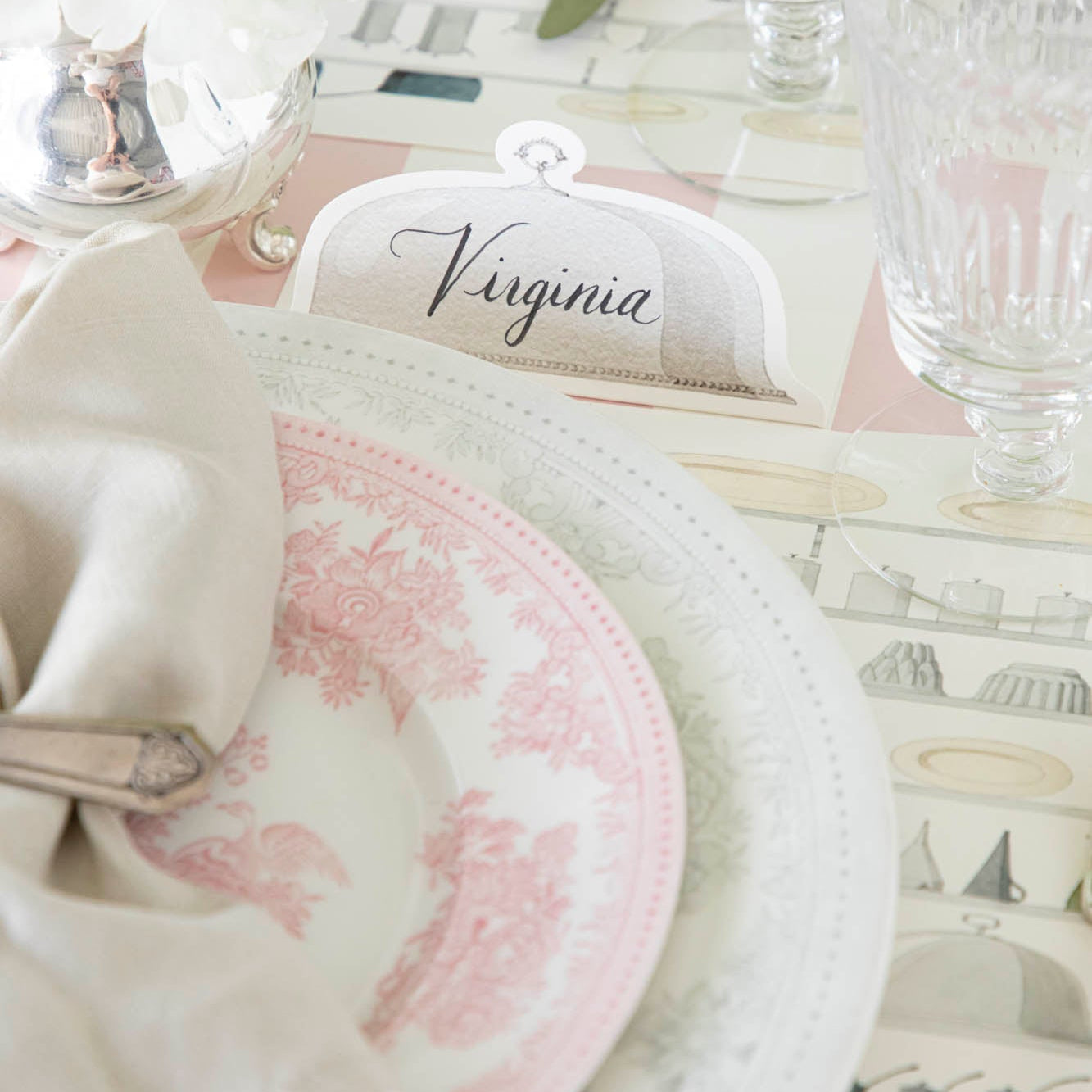 Serving Dome Place Card with "Virginia" on it, behind an elegant place setting for one.