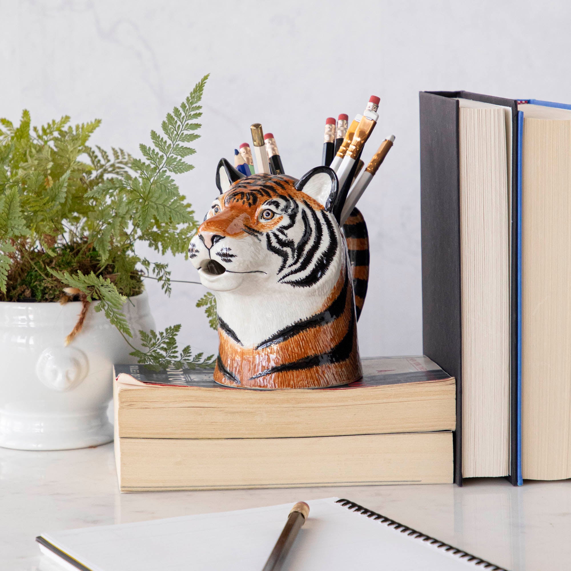 A set of quirky Quail tiger ceramic vases on a wooden table.