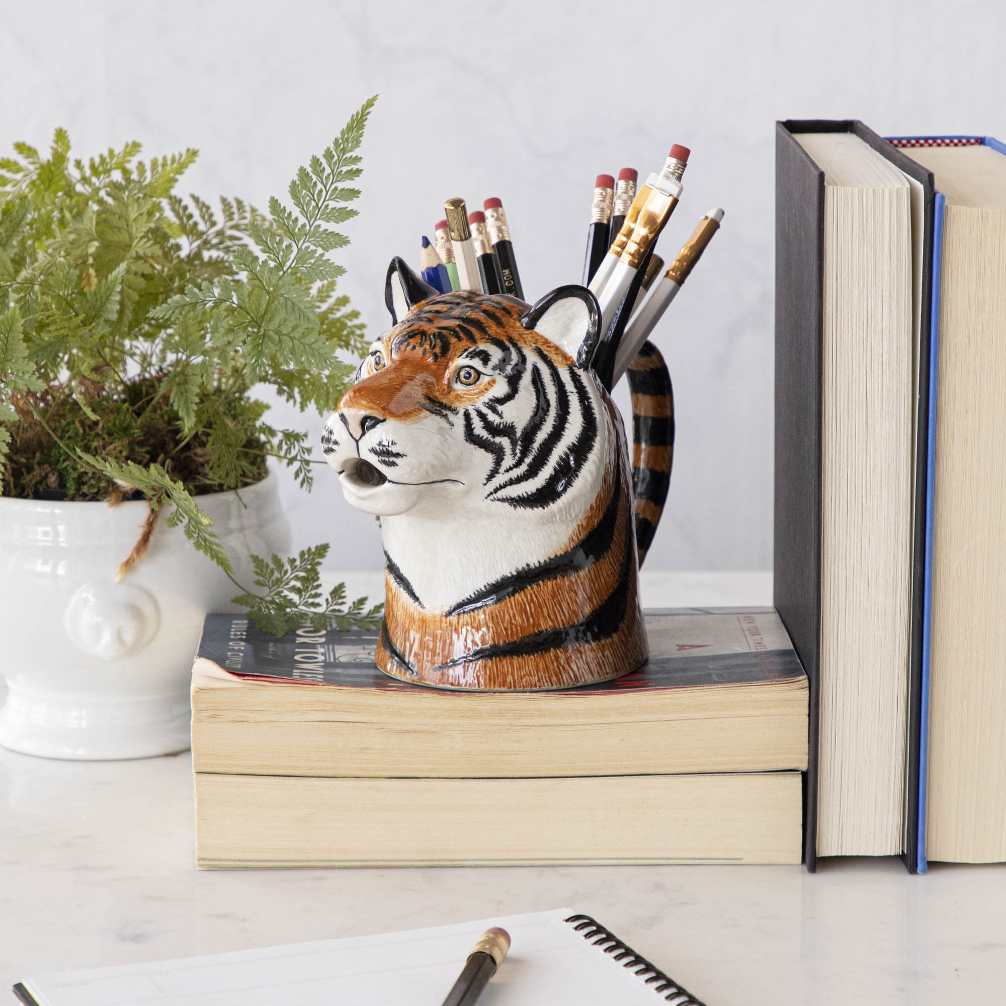 A set of quirky Quail tiger ceramic vases on a wooden table.