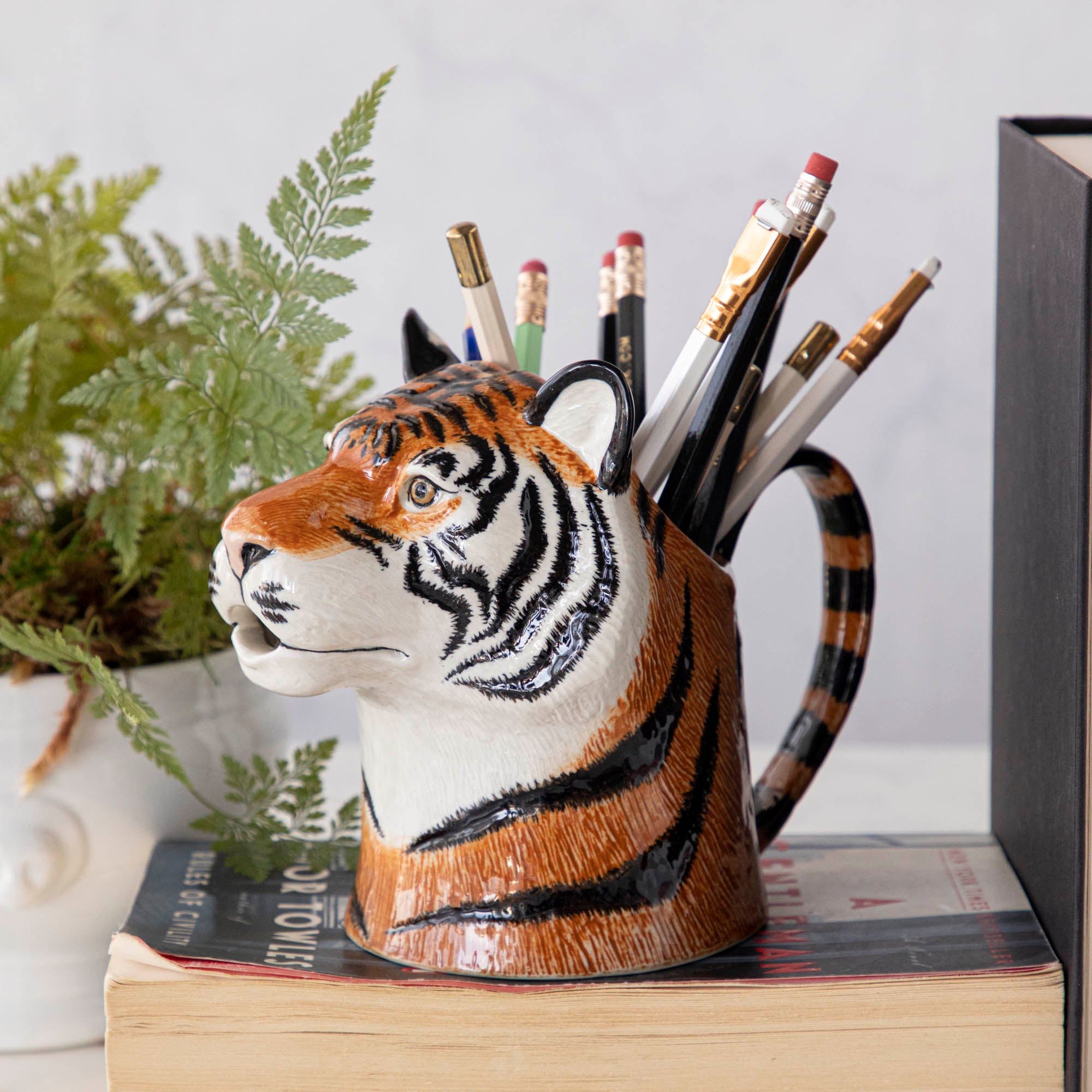 A set of quirky Quail tiger ceramic vases on a wooden table.