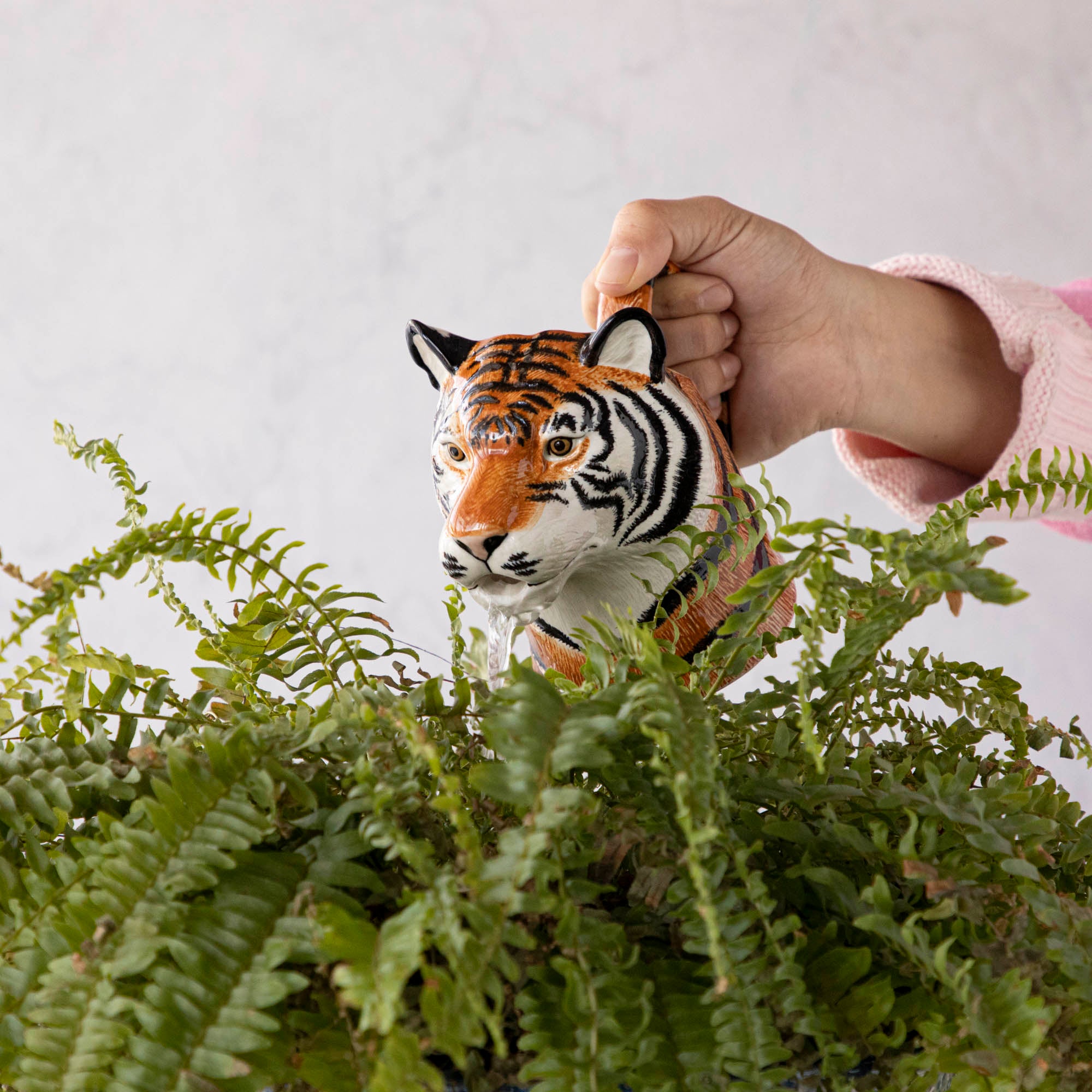 A set of quirky Quail tiger ceramic vases on a wooden table.