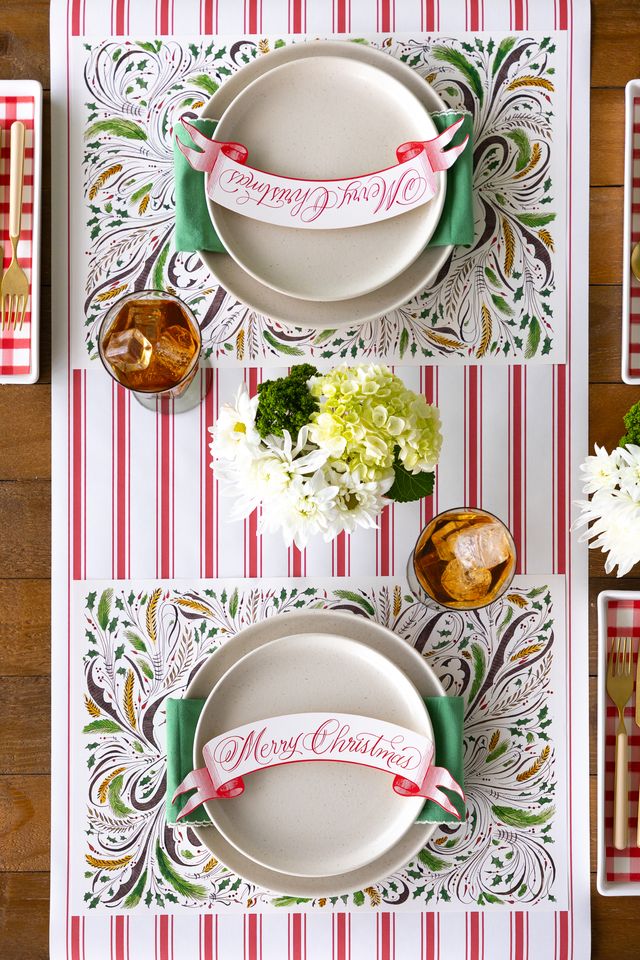 Decorative Christmas table setting with patterned placemats and white plates.