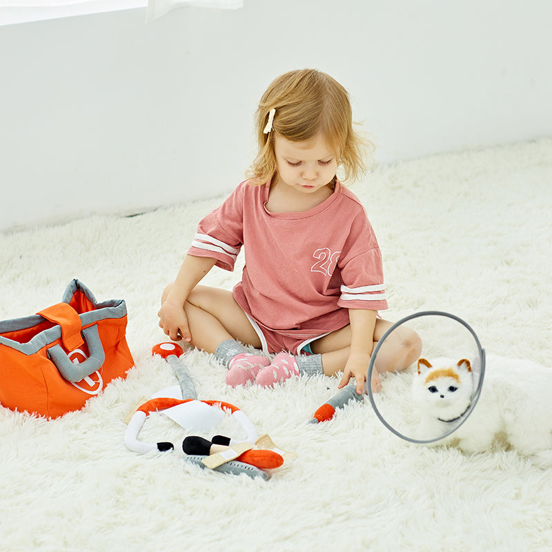 A child playing with the stuffed animal vet bag.