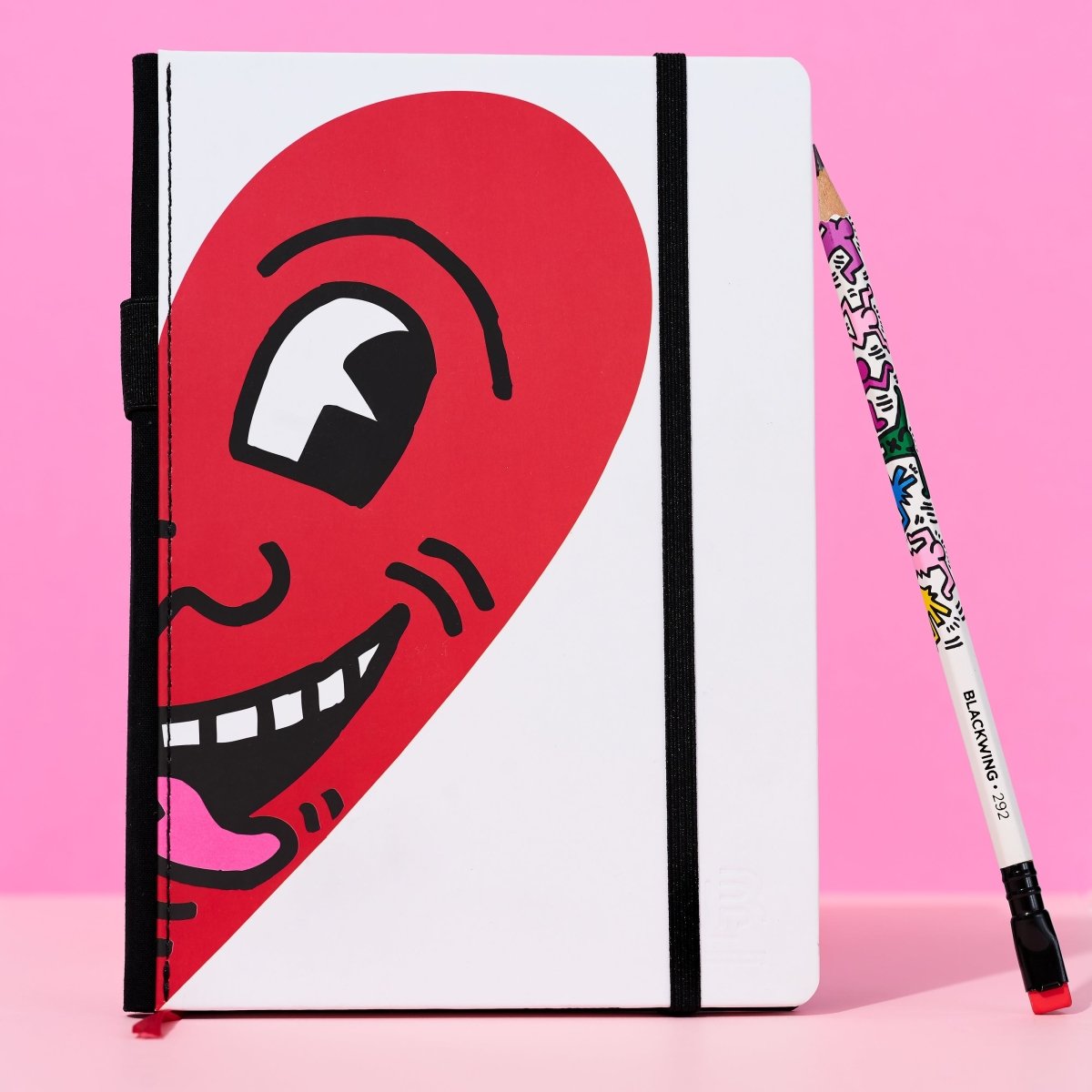Blackwing notebook featuring artwork by Keith Haring of a half of a heart with a face on it.
