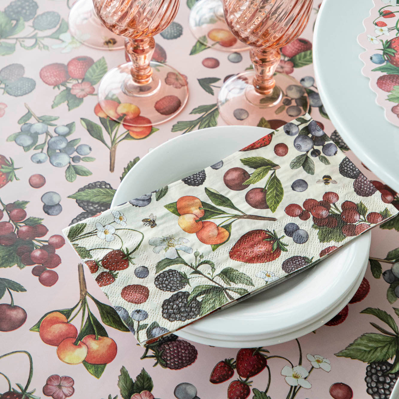 Wild Berry Guest Napkins on a stack of plates on the Wild Berry Runner.