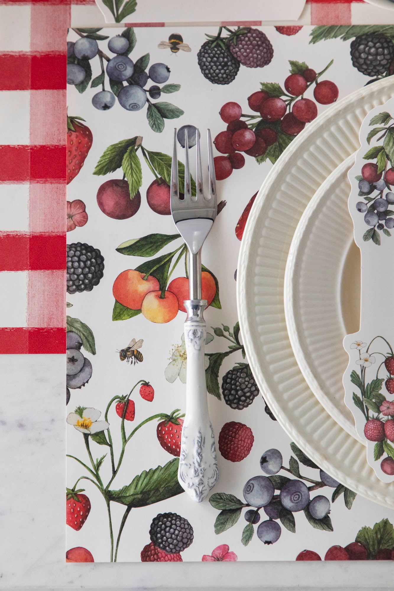 Close-up of the Wild Berry Placemat under an elegant summertime place setting, from above.