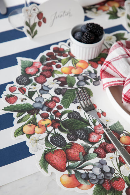 Close-up of the Die-cut Berry Wreath Placemat under an elegant place setting, showing the artwork in detail.
