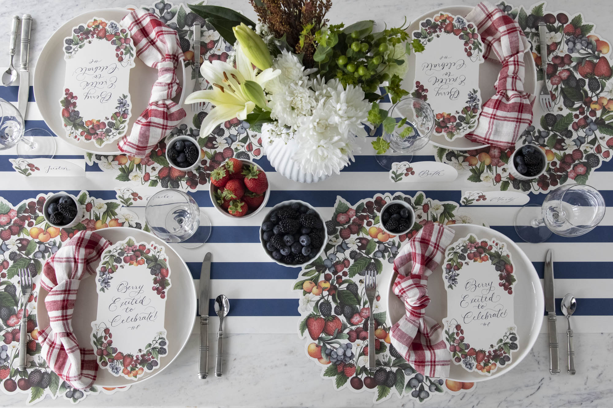 The Die-cut Berry Wreath Placemat under an elegant table setting for four, from above.