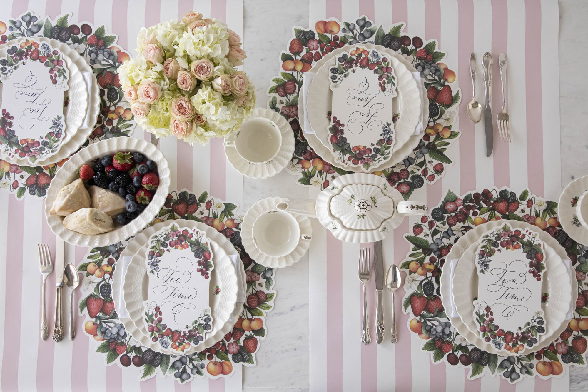 Top-down view of an elegant summertime table setting for four featuring Berry Bramble Table Cards resting on each plate.